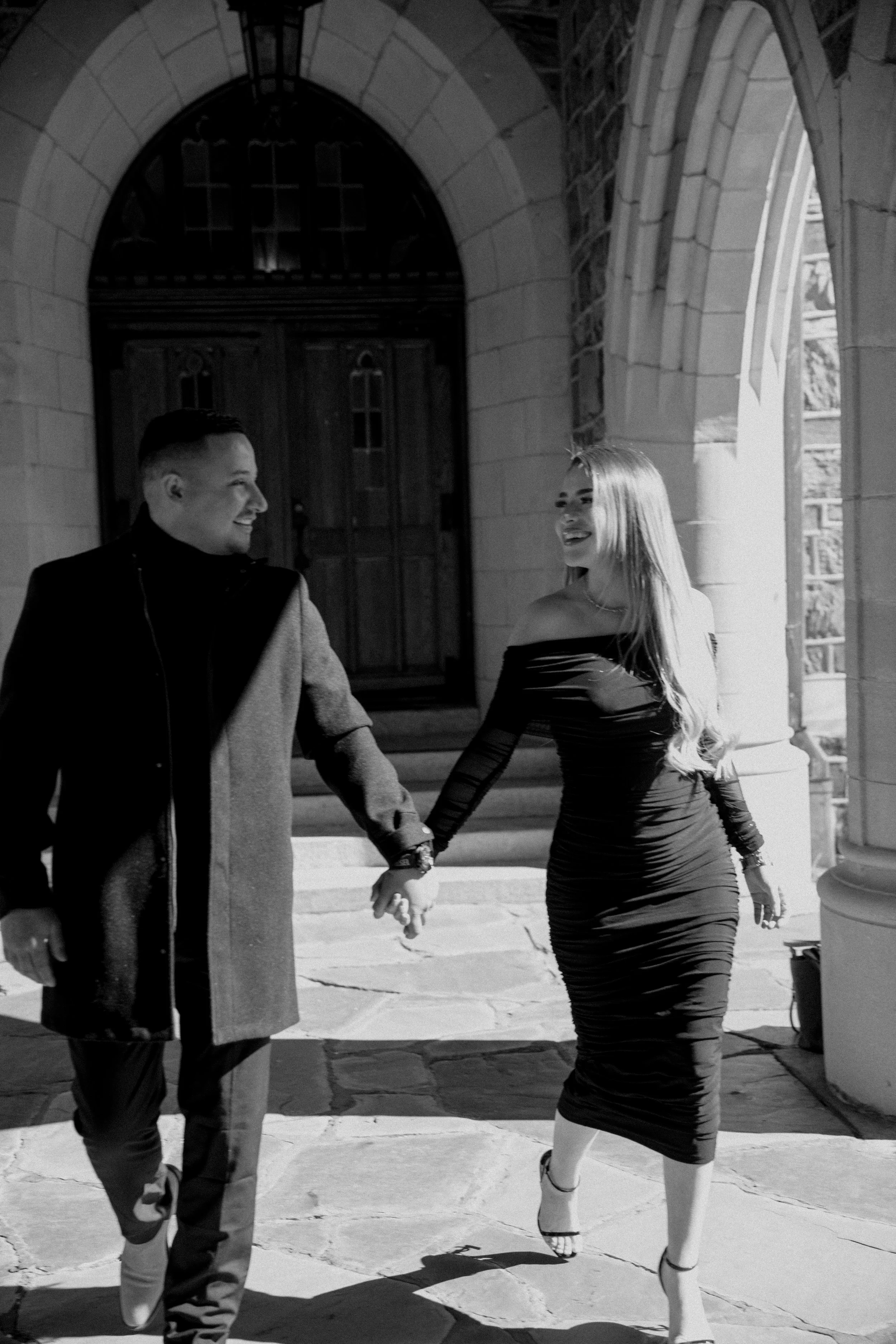 Black and white couple portrait holding hands under stone archway