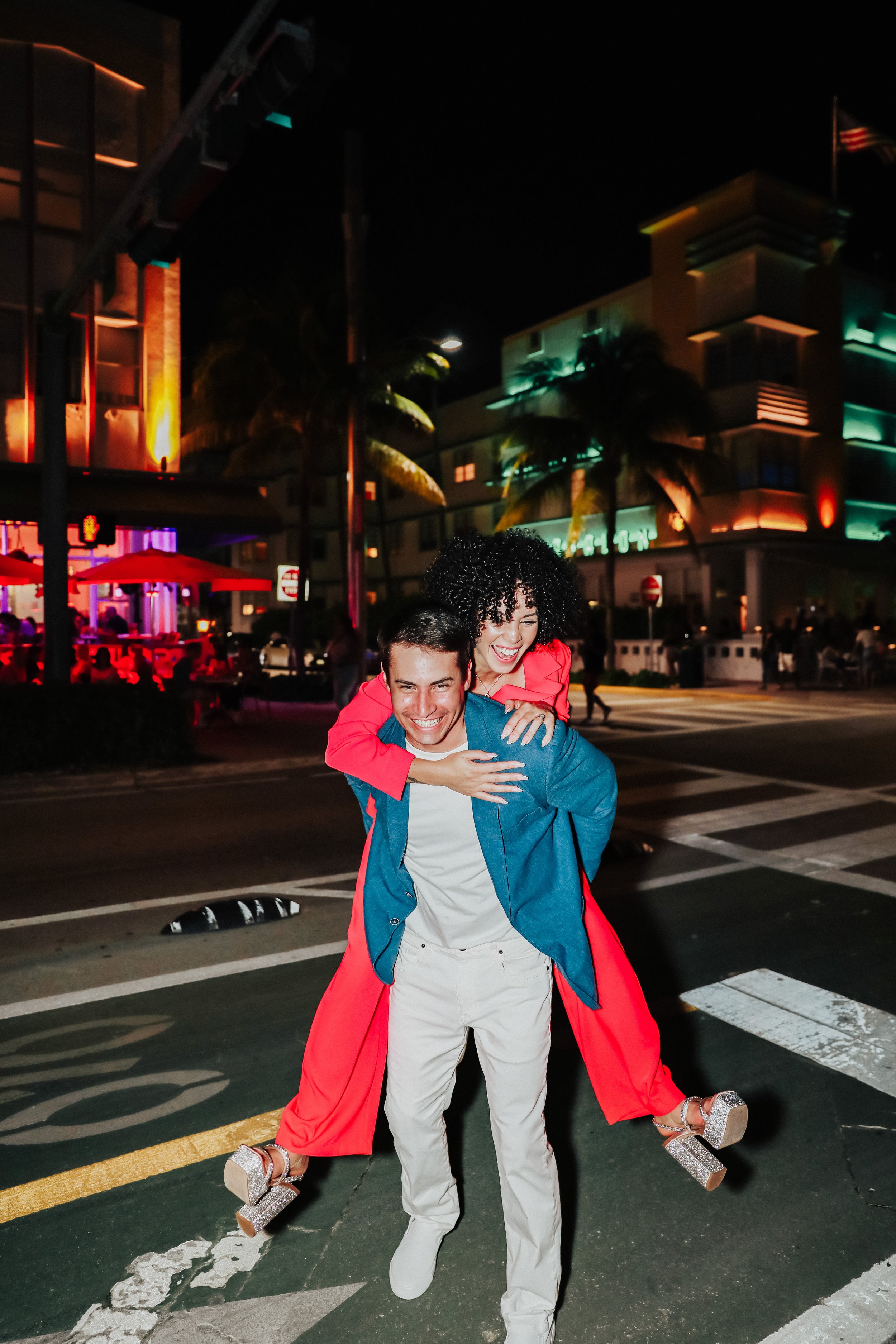 Groom carrying bride across street at night