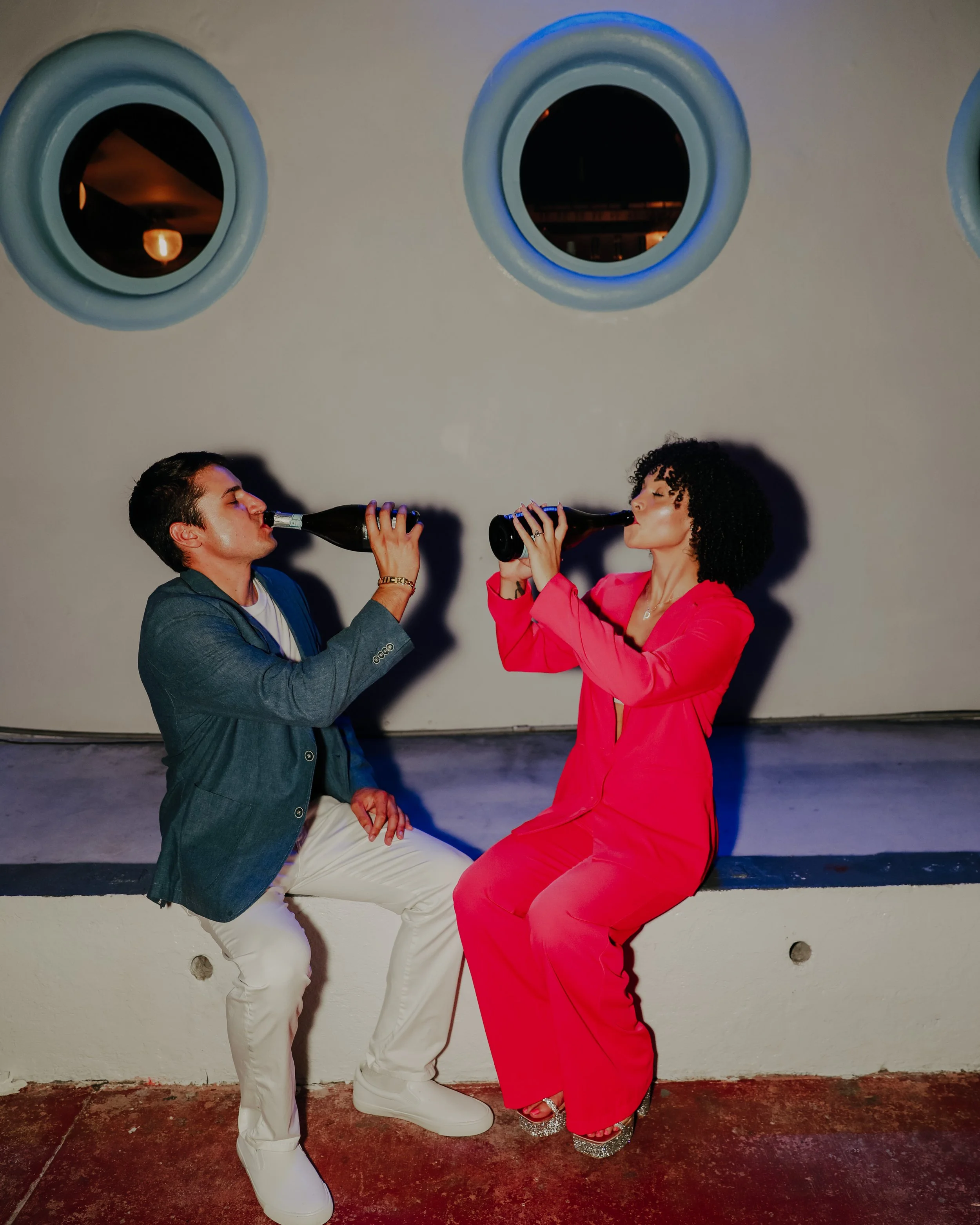 Couple drinking together during fun engagement shoot