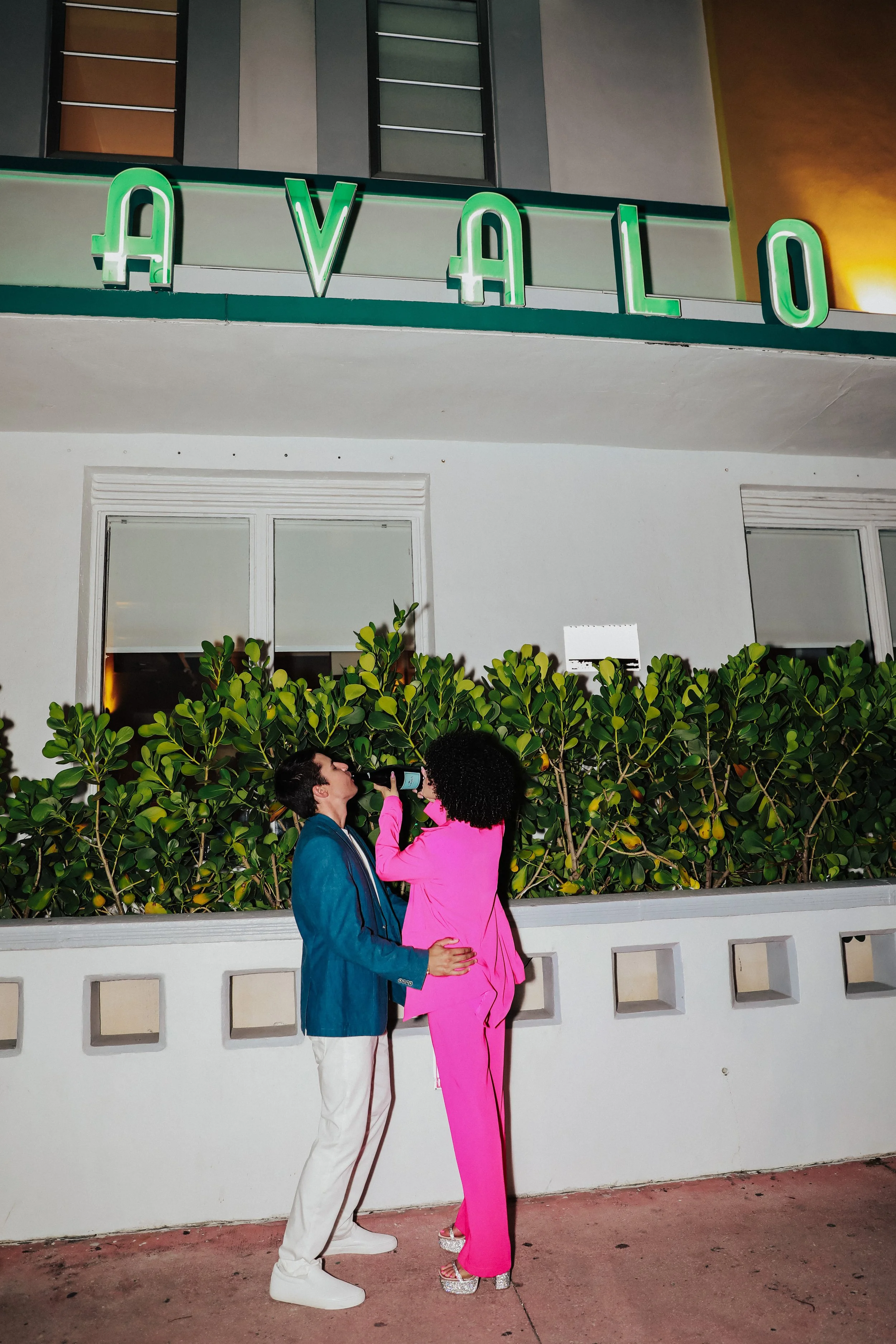 Couple standing outside building with green lighting