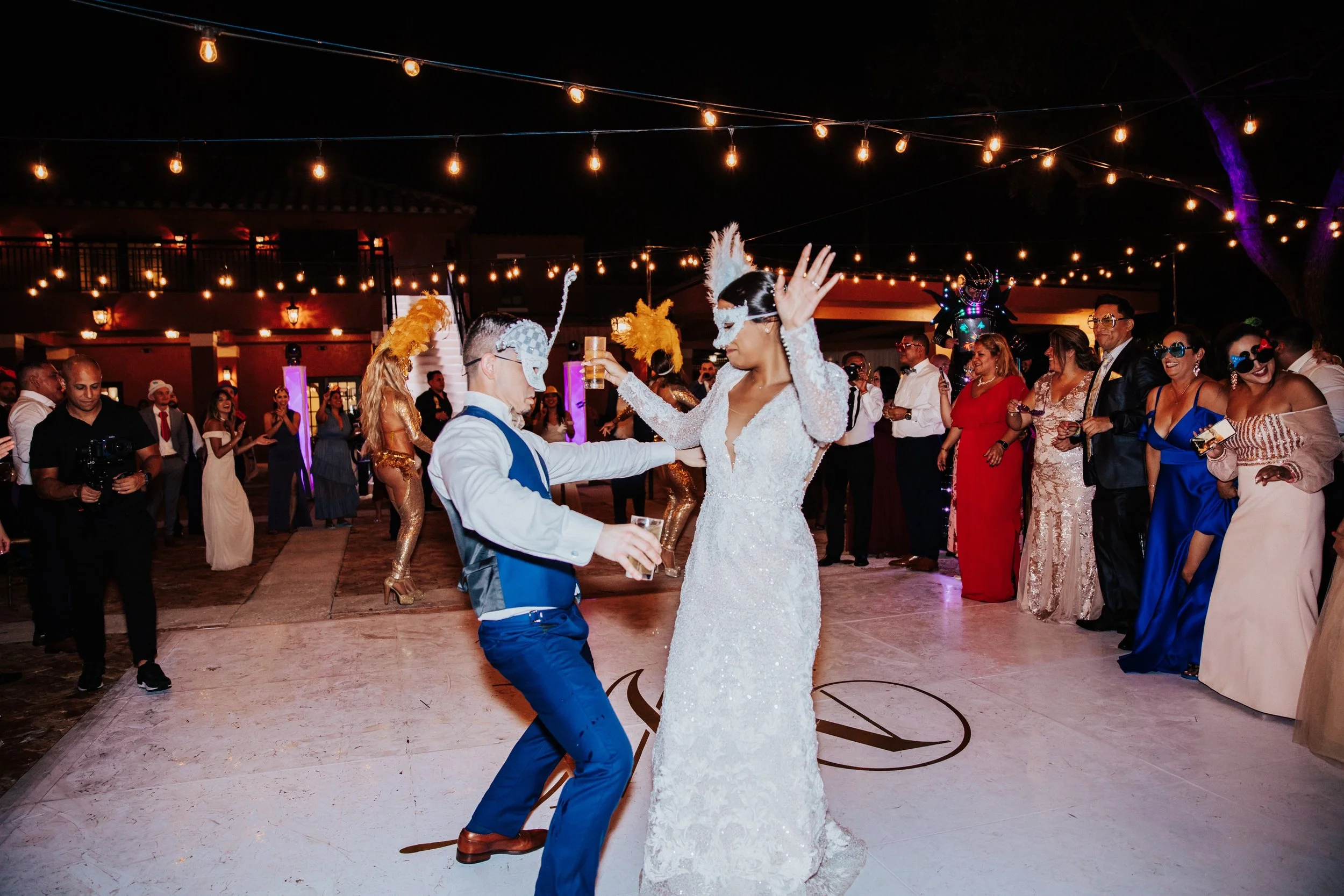 Bride and groom dancing under string lights at night