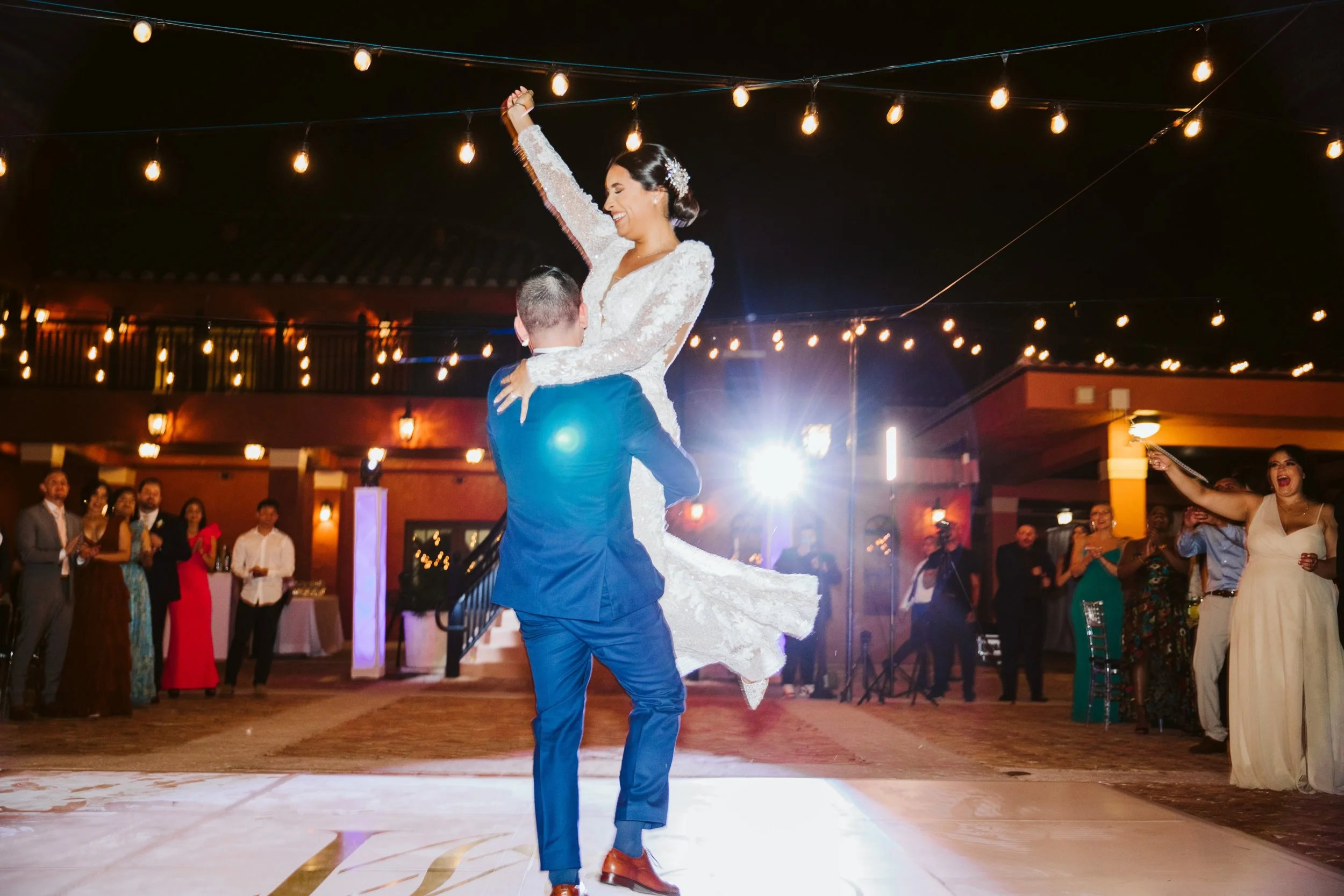 Groom lifting bride during wedding dance floor moment