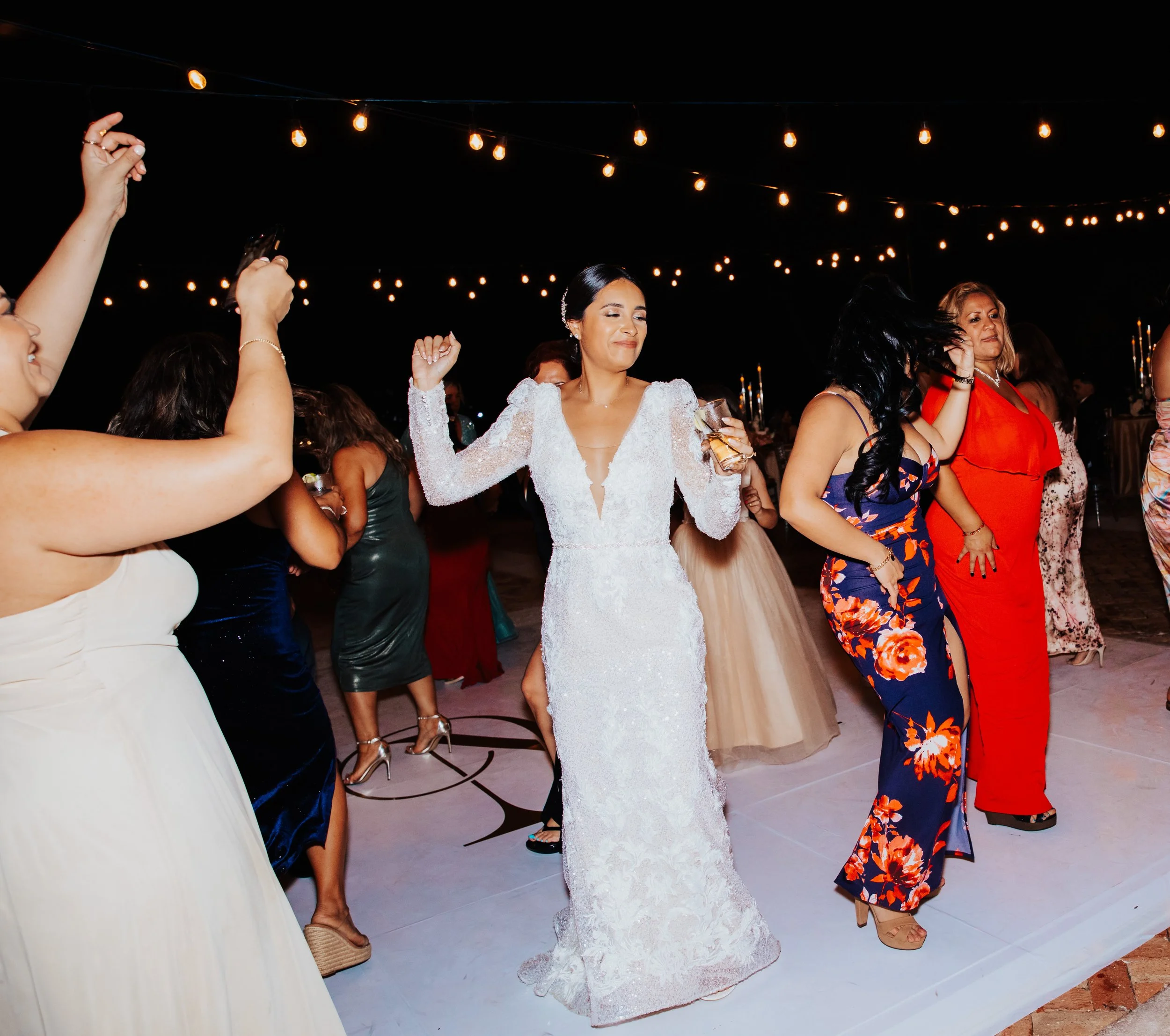 Bride dancing with friends on crowded dance floor