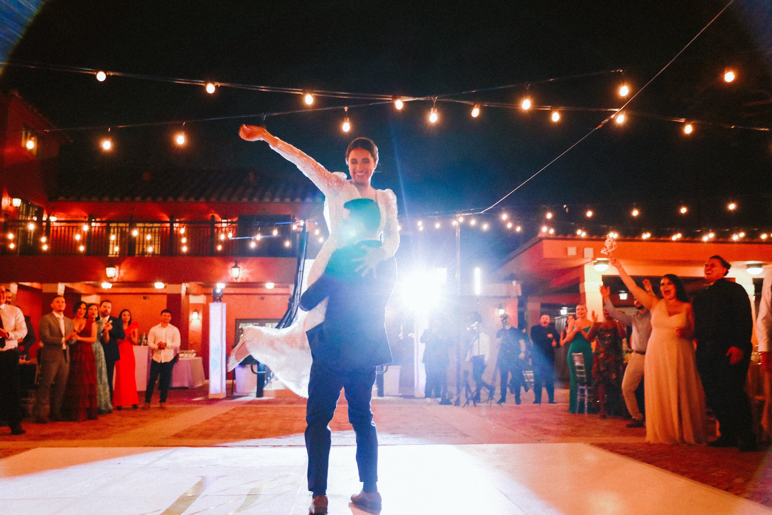 Groom celebrating with spotlight during wedding reception
