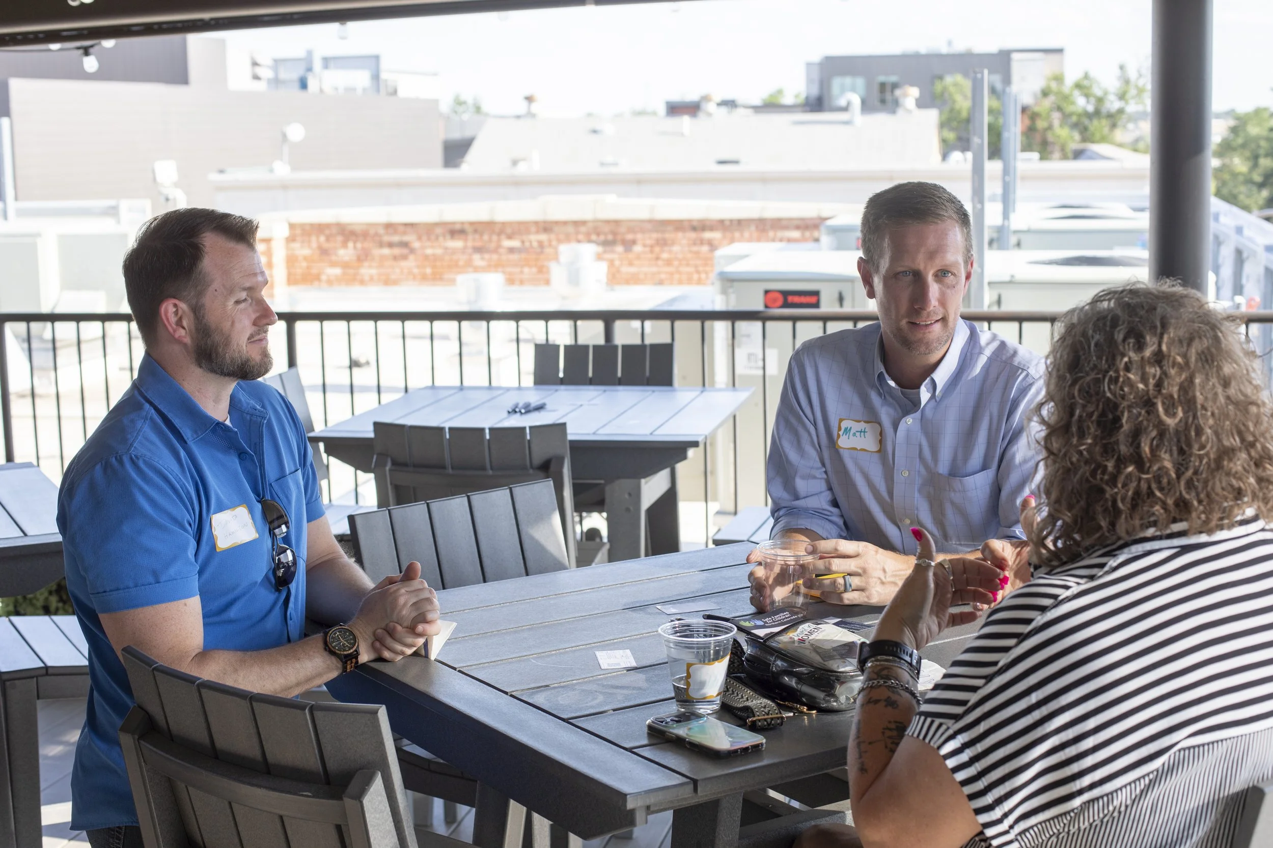 Two men and a woman chatting at a Rally NoCo event