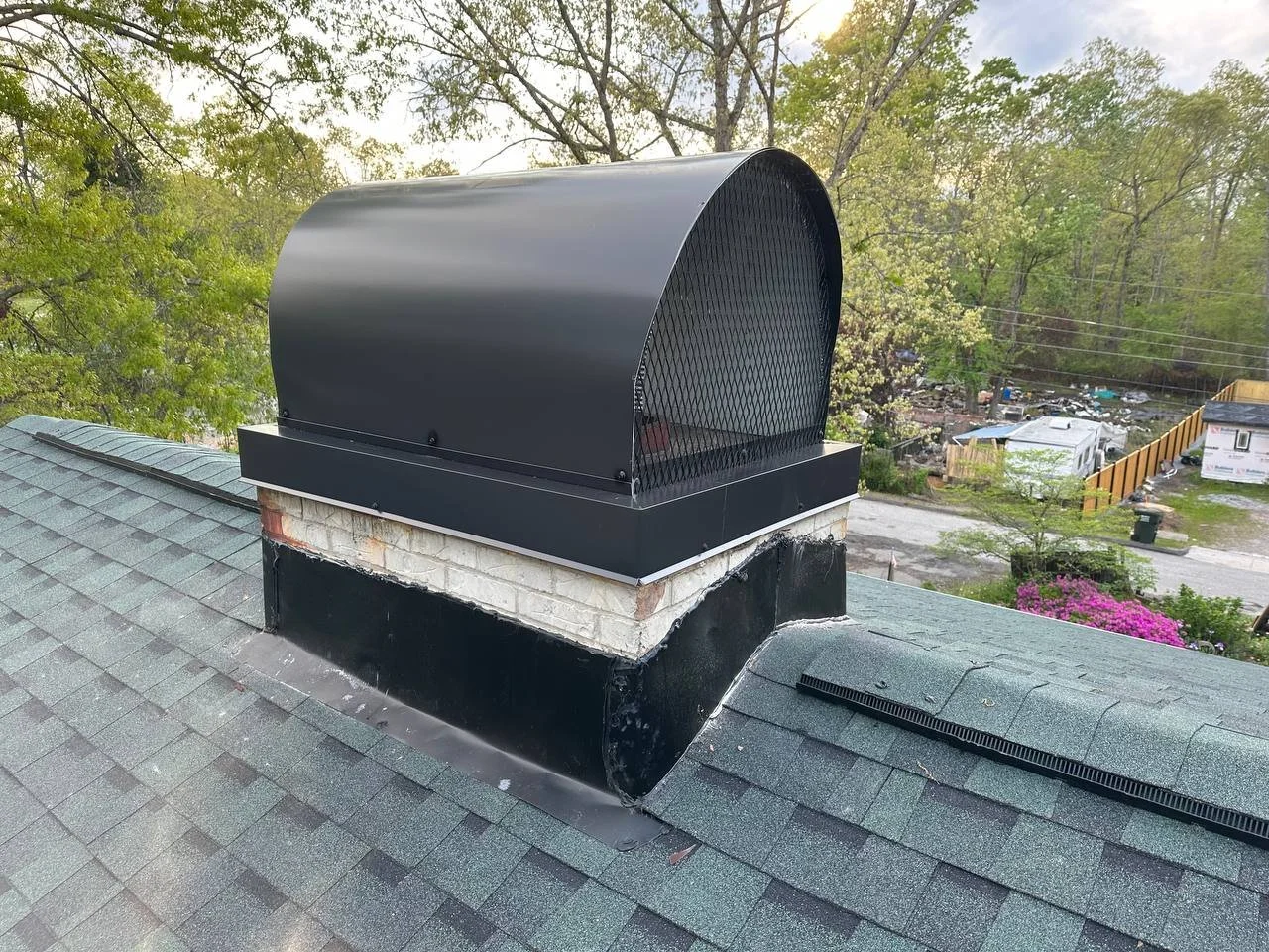 Metal chimney flashing installed to prevent roof leaks around a chimney.