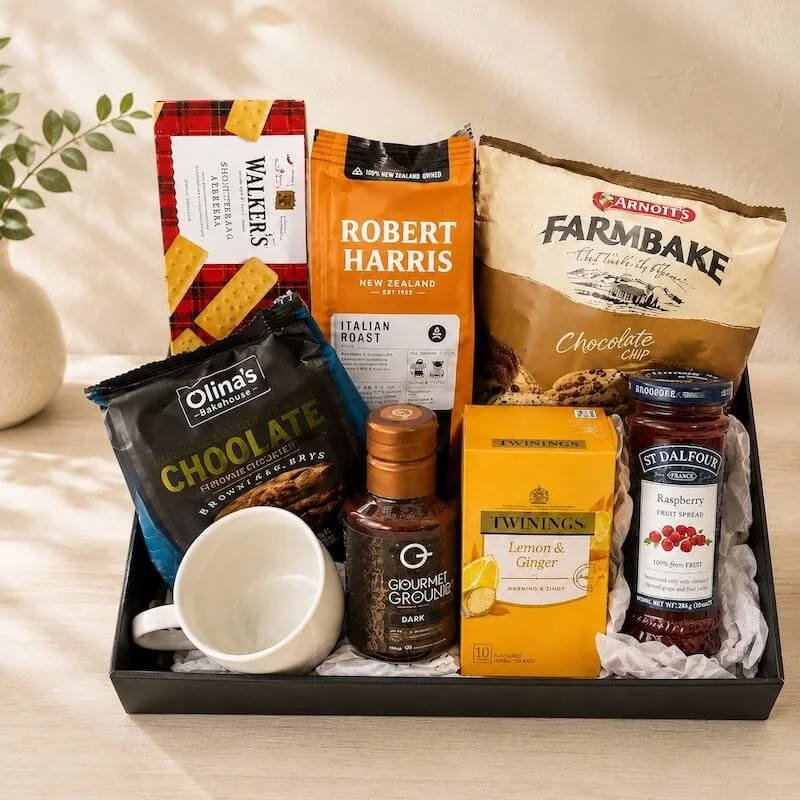 Gift hamper with jam, tea, coffee syrup, cup, cookies, biscuits and coffee and cookies.