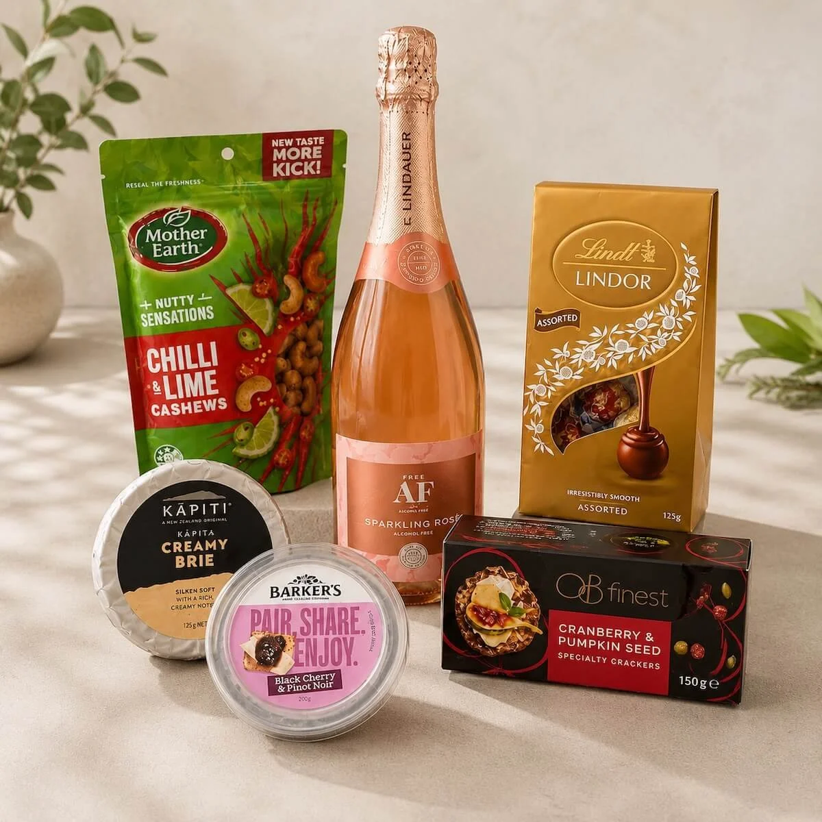 Dip, Cheese, Crackers, Chocolates and Cashew nuts showen with the AF wine ion a bench.