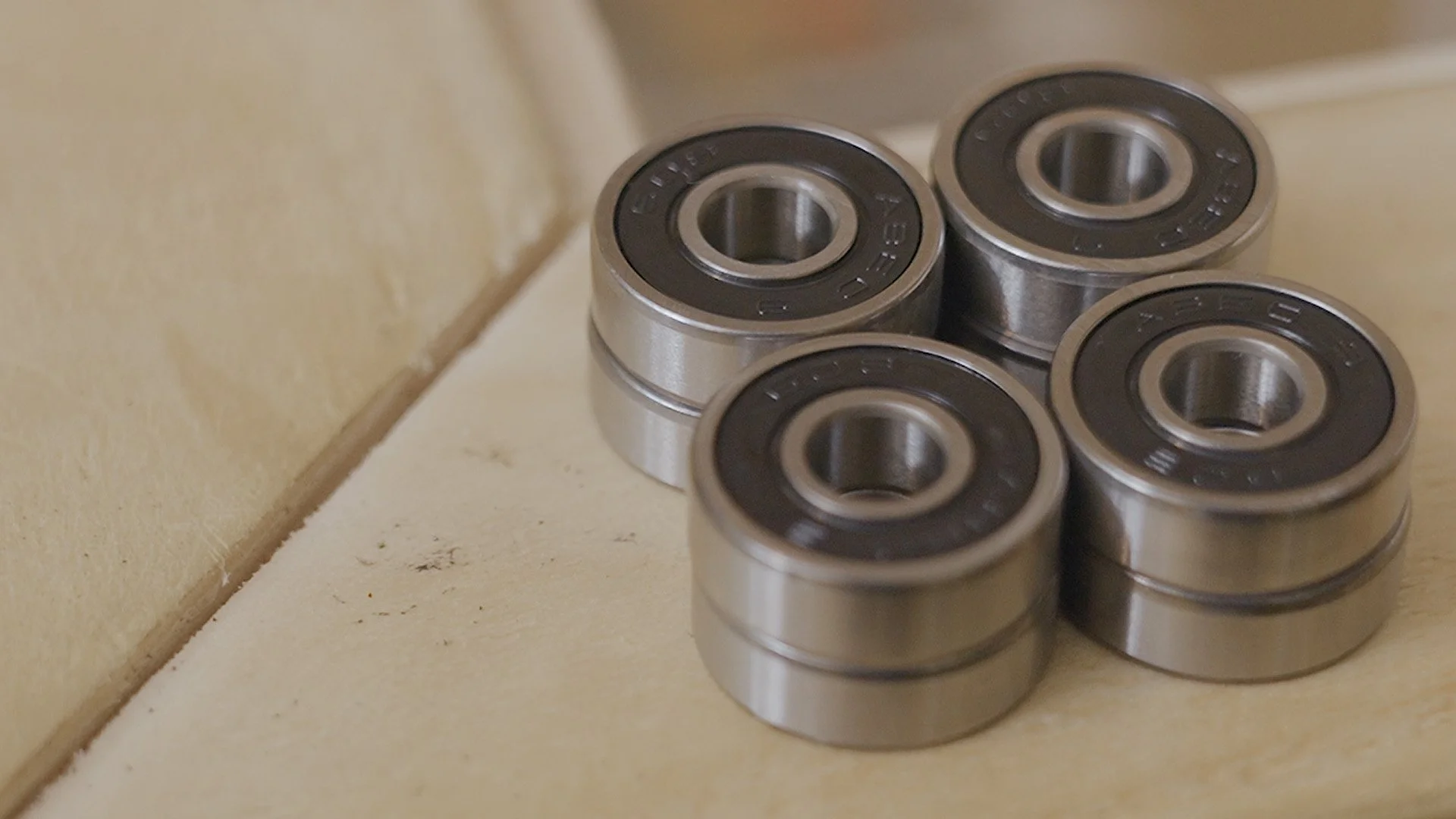 Six metal ball bearings placed on a beige surface near a wall.
