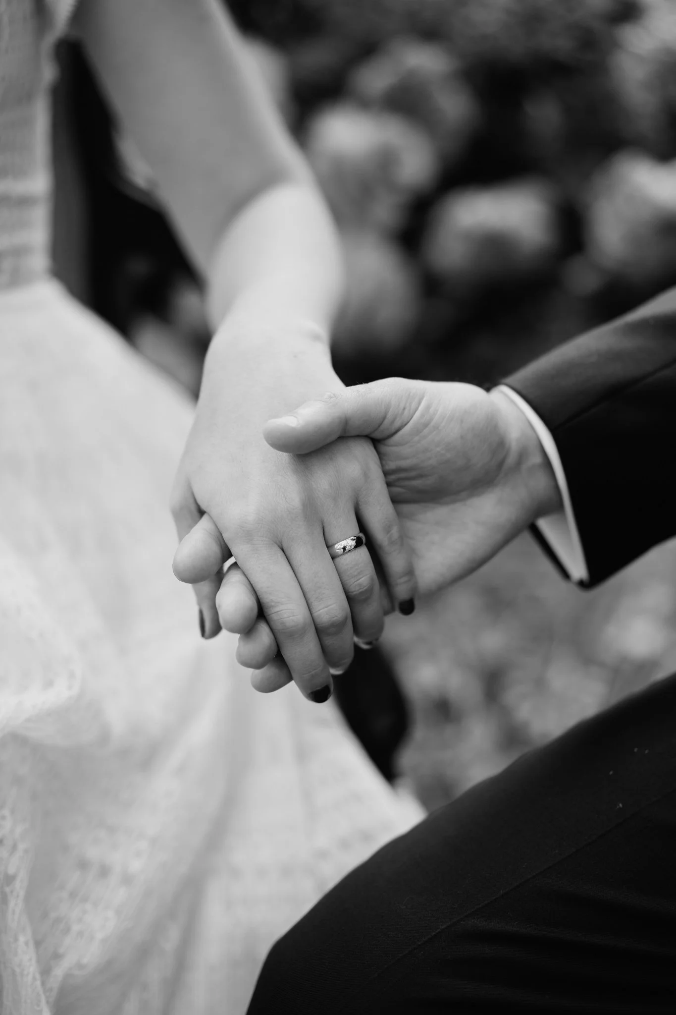 Mani di una donna e di un uomo che si tengono saldamente, con un anello sul dito della donna, simbolo di matrimonio o impegno.