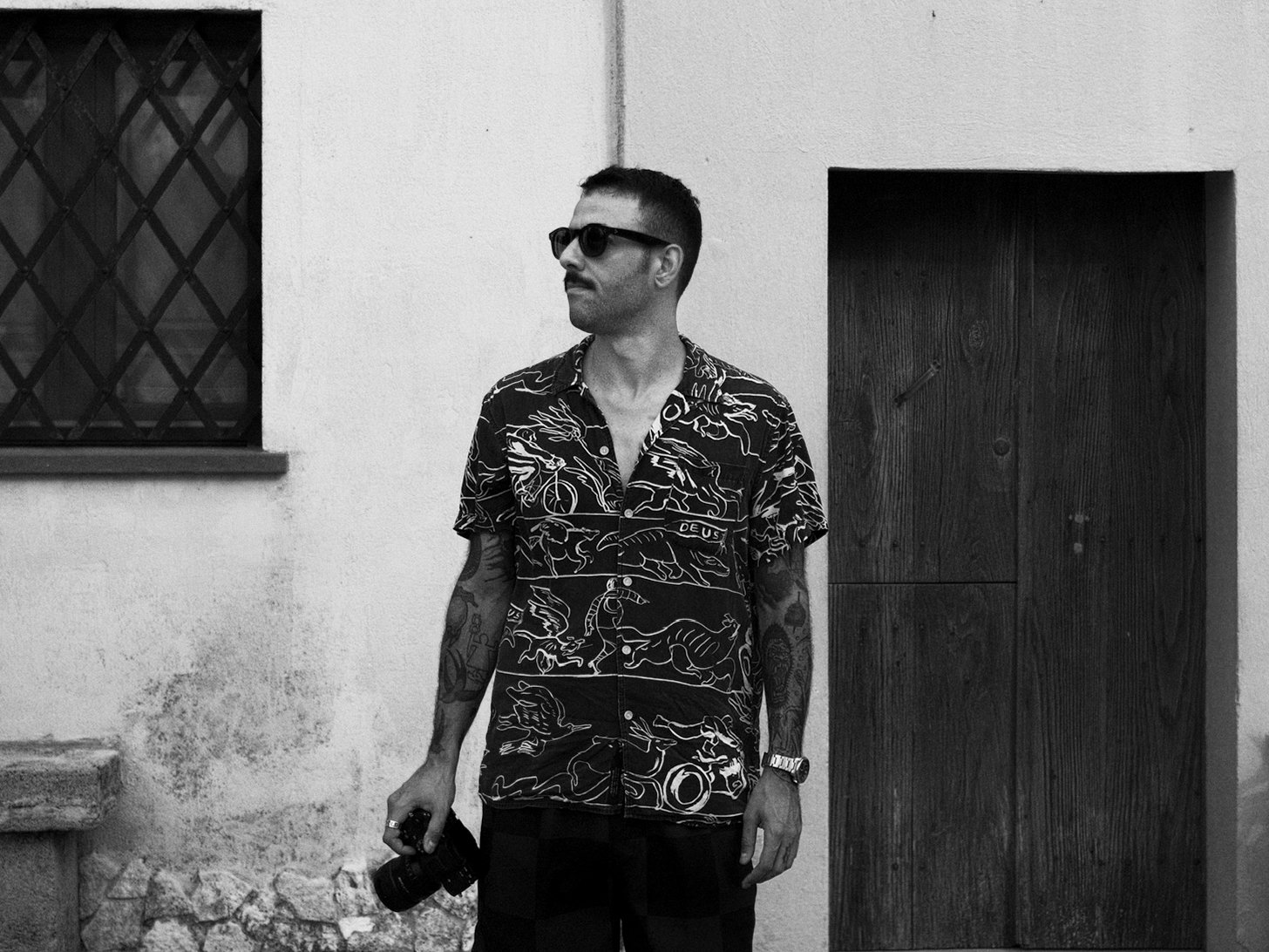 Un fotografo con fotocamera in mano in bianco e nero.