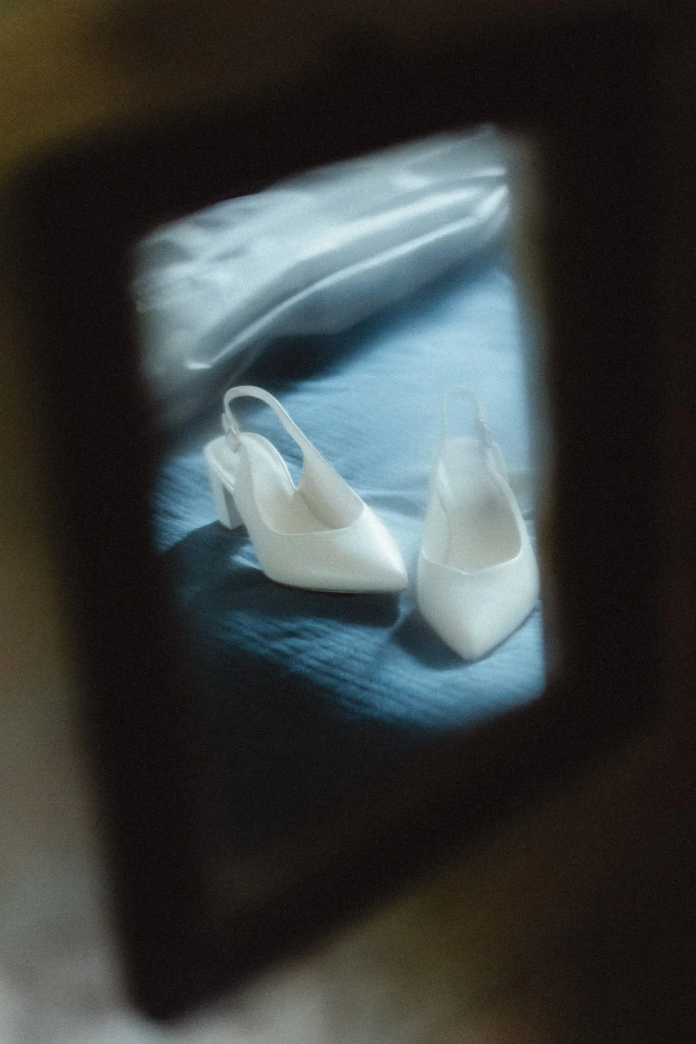 Scarpe bianche con tacco alto viste attraverso una presa