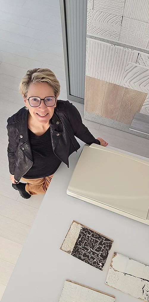 portrait of Annemie Van de Casteele in her studio with prints of her work on the wall, surface designer