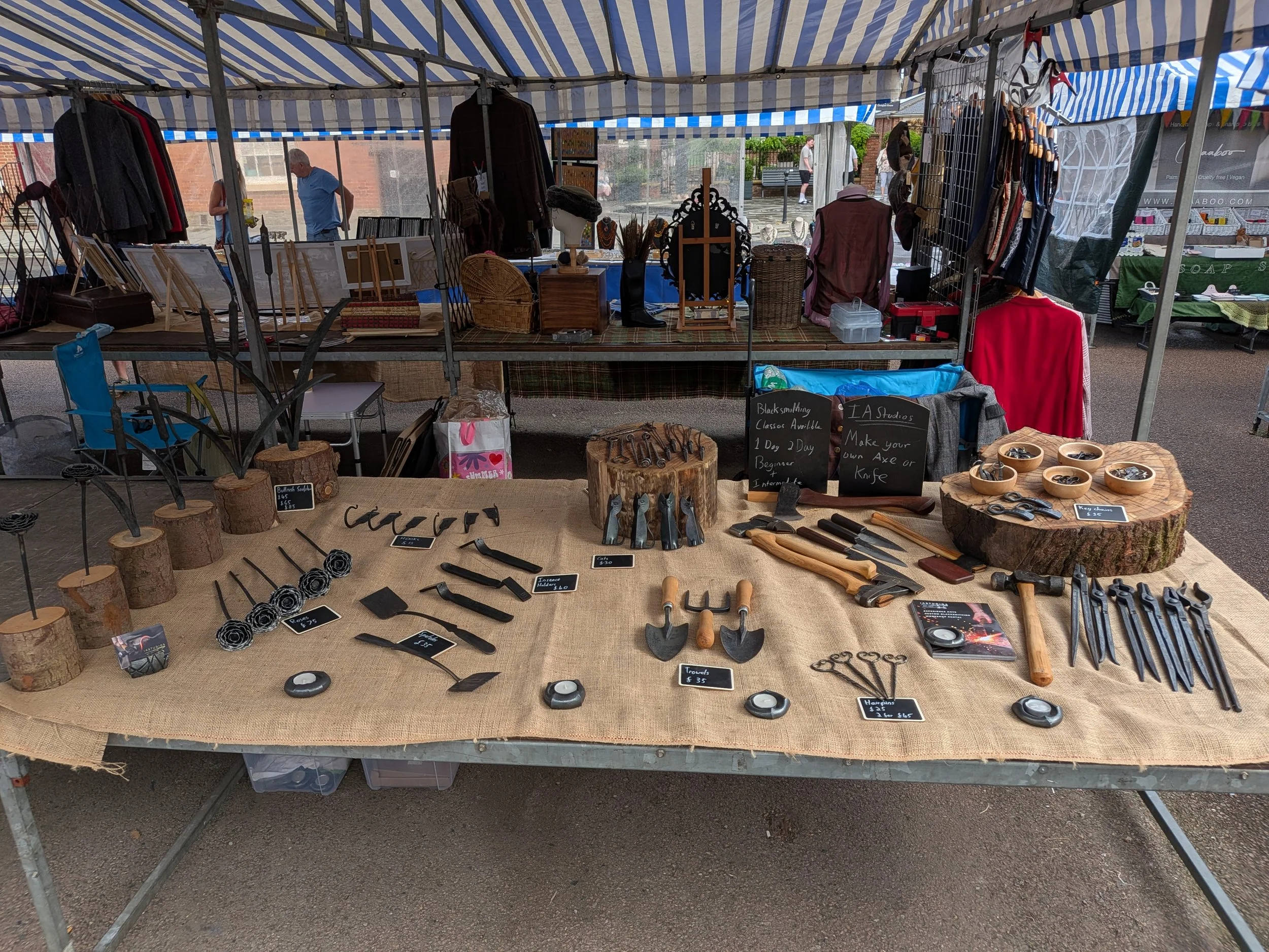 A market stall exhibiting a range of hand forged items made by blacksmiths