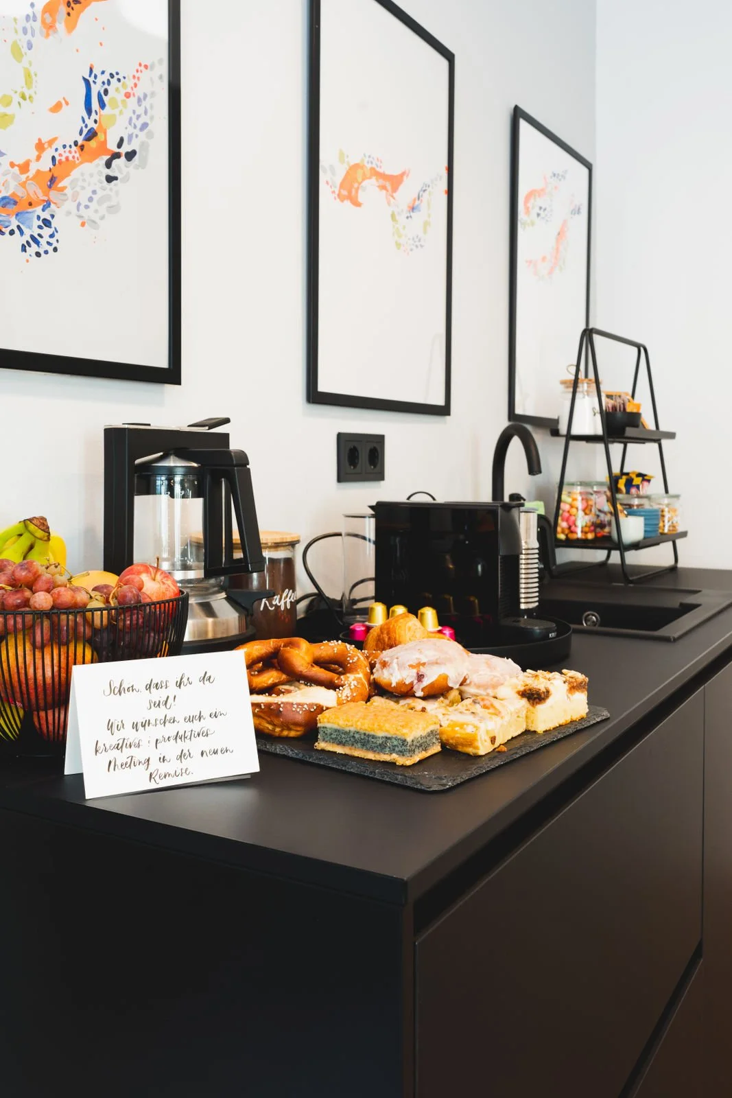 Kaffee- und Snackbereich in der Neuen Remise mit frischem Obst, Gebäck und einer Kaffeemaschine. Die stilvolle Präsentation von Snacks und Getränken fördert eine kreative und entspannte Atmosphäre für Meetings und Workshops.