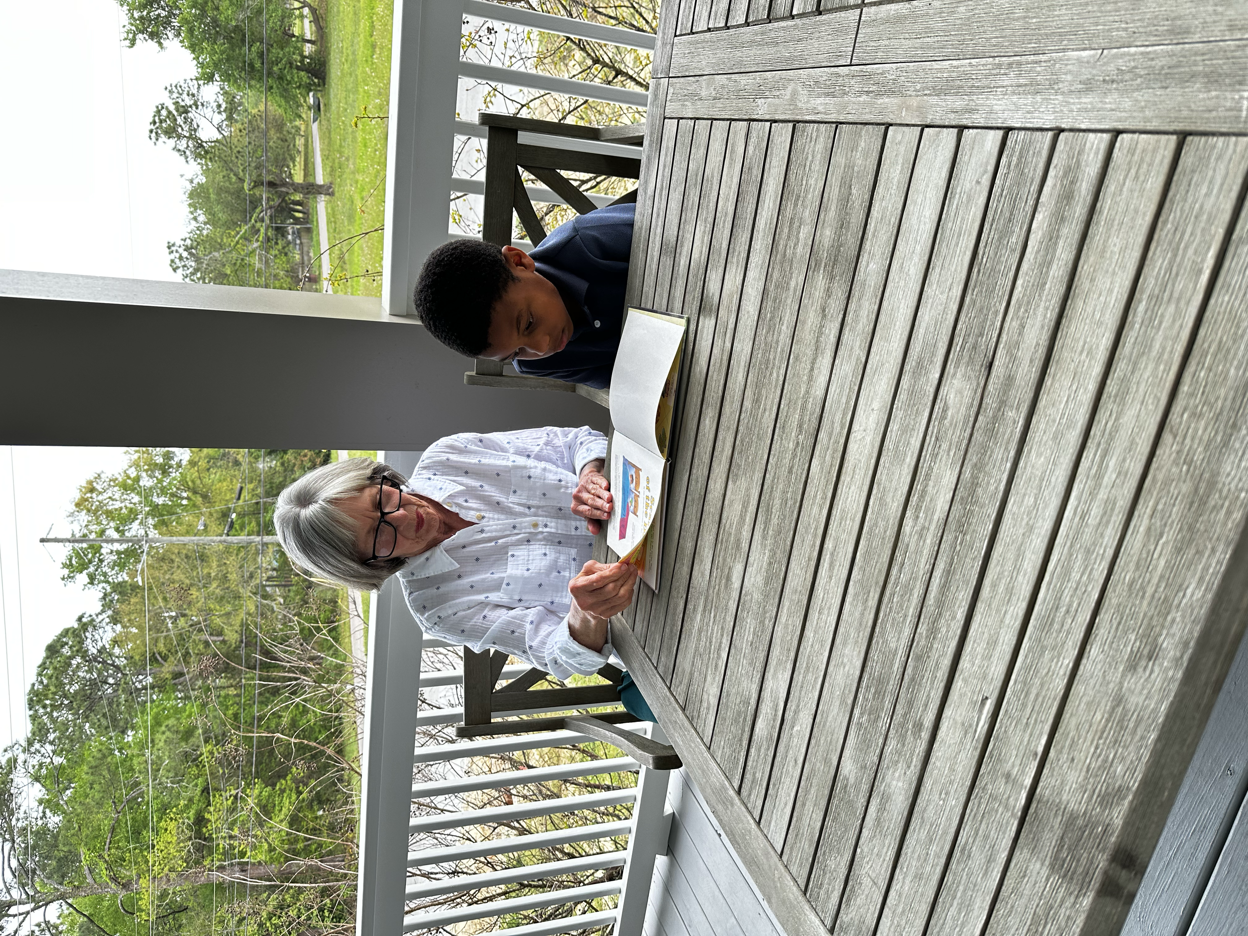 Ms. Meg and Laurent enjoying reading on the porch.
