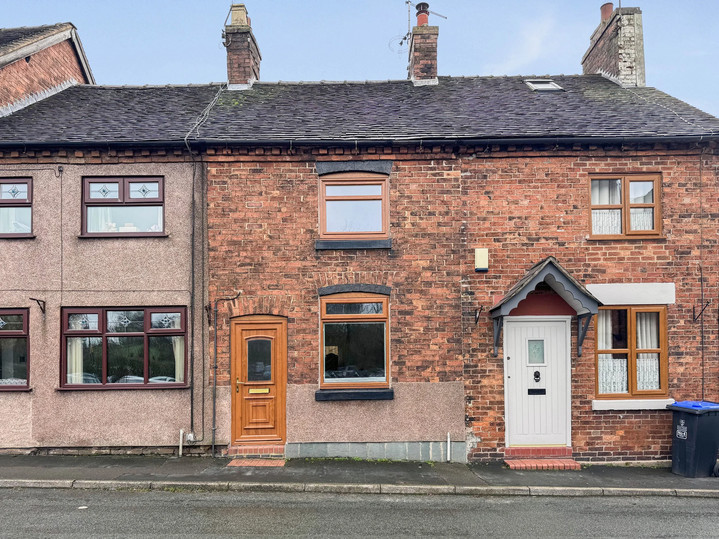 Front elevation of a Victorian red brick cottage on Old Road, Tean, with brown door and sash-style windows.