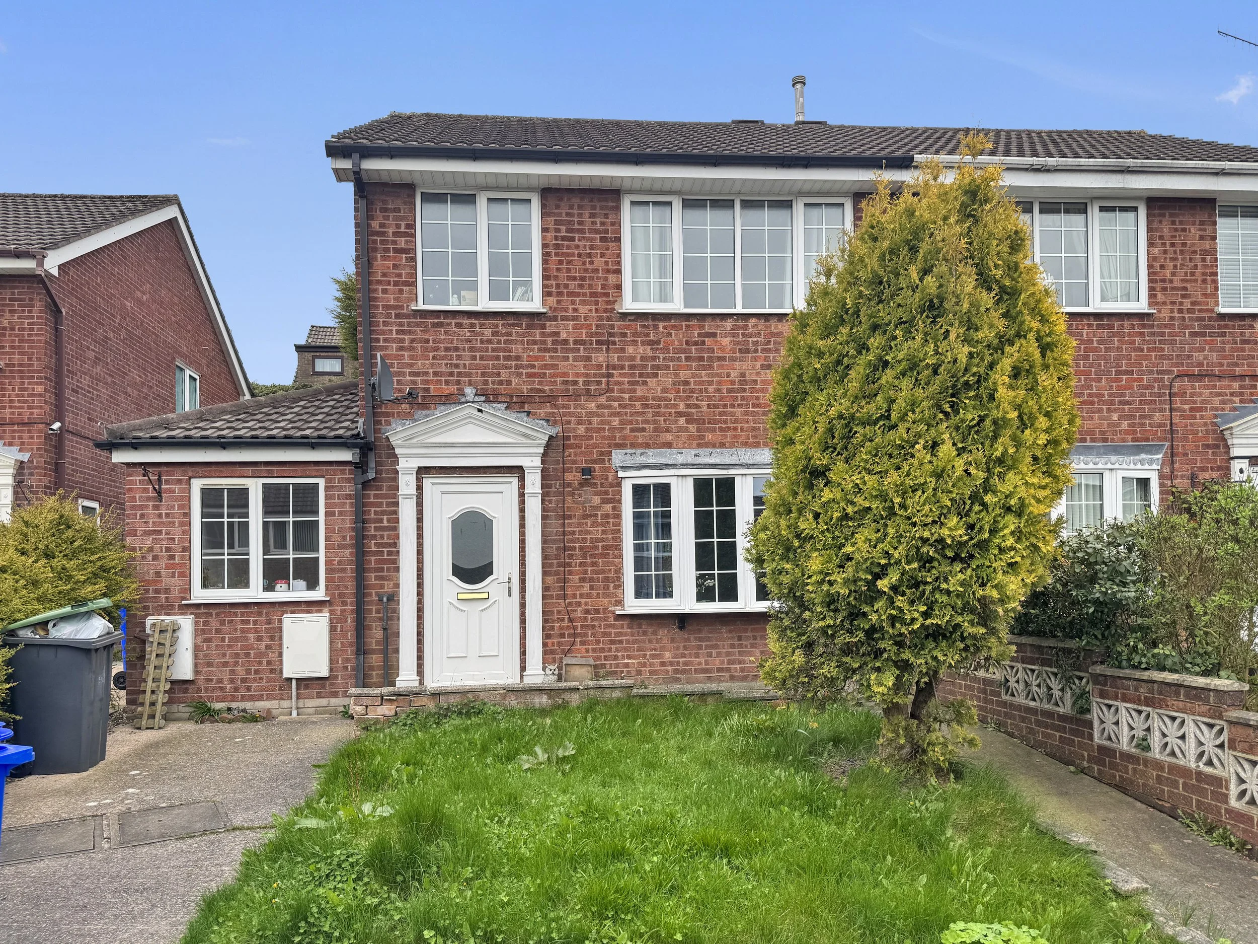 Front elevation of a three bedroom semi-detached brick house on Webster Avenue, Parkhall, Stoke-on-Trent with driveway, lawned front garden and bay window