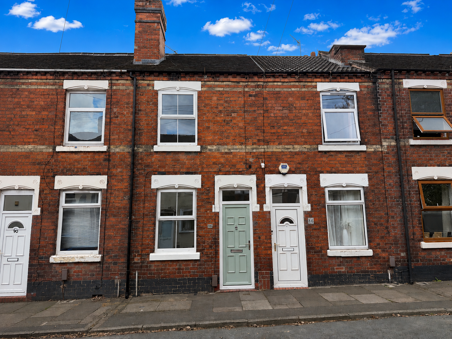 Front exterior of a two bedroom Victorian red brick terrace house for sale on Duke Street, Heron Cross, Stoke-on-Trent, with a pale green front door and traditional period frontage.