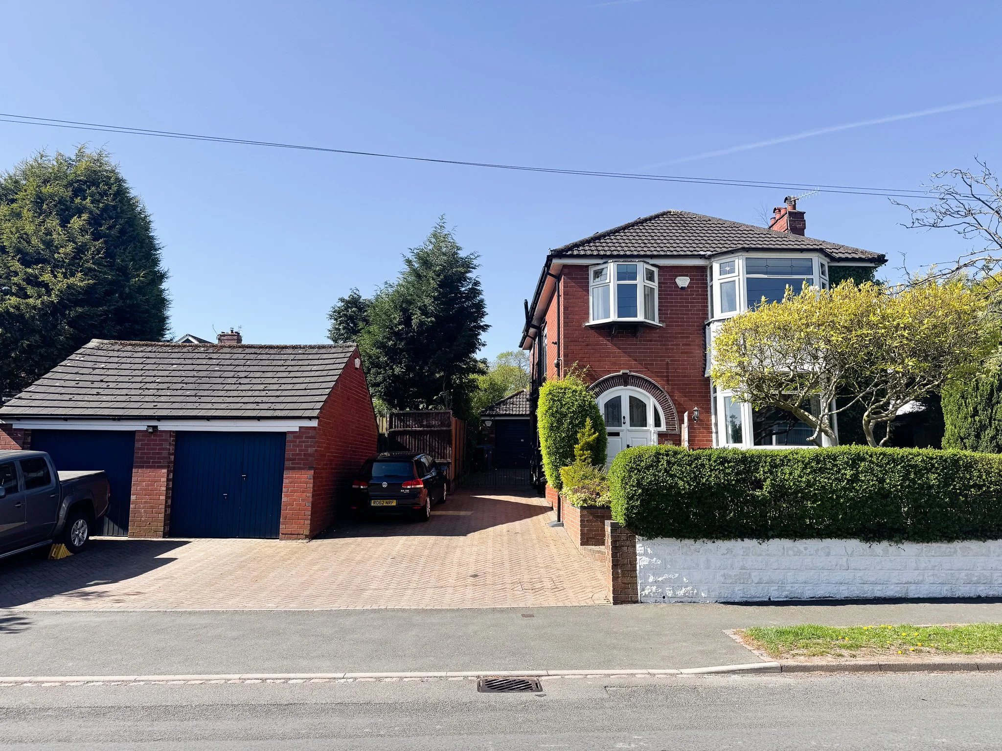 Front view of extended detached house on Maythorne Road Blurton with large driveway, detached double garage, red brick exterior and bay windows
