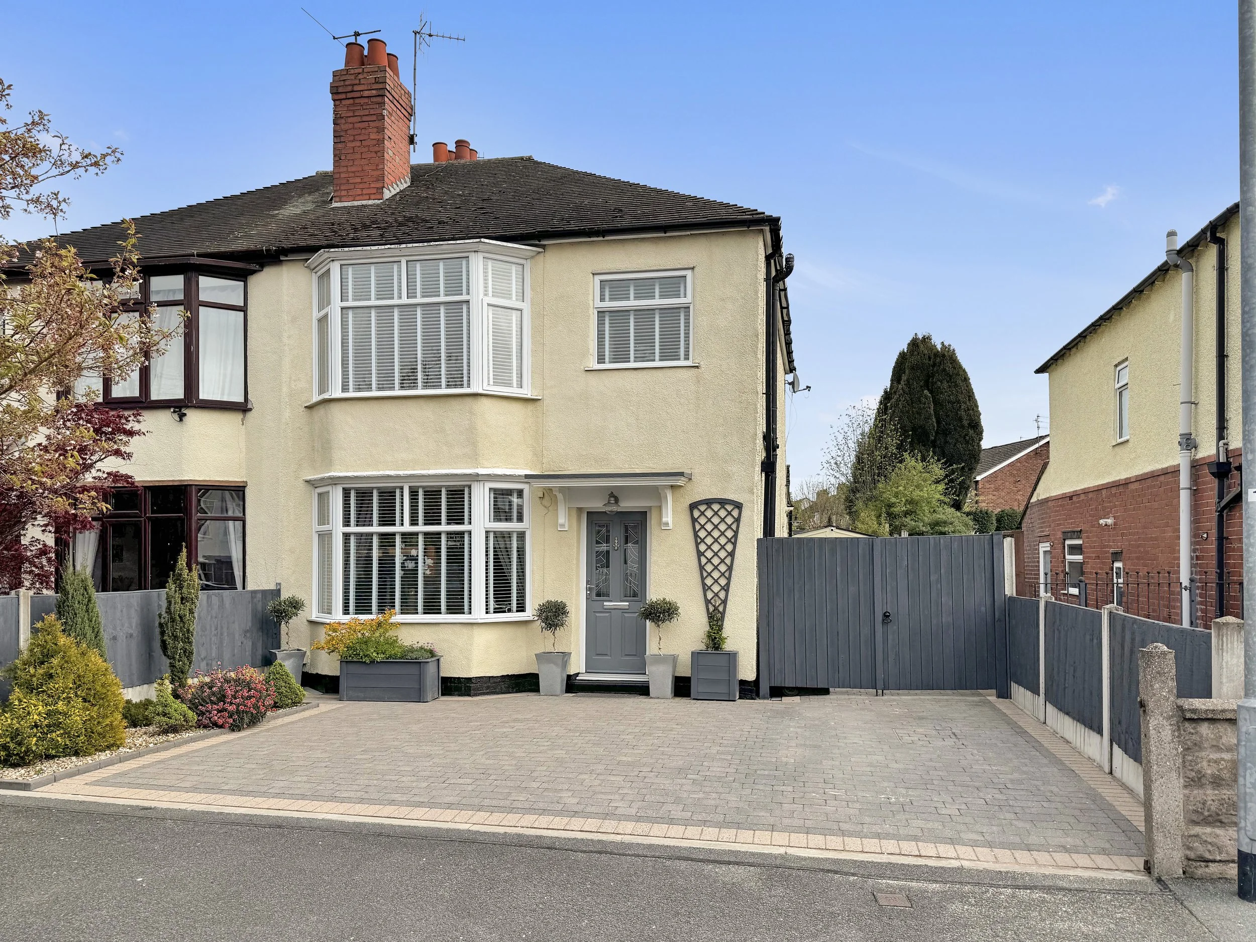 Front view of a beautifully presented three-bedroom semi-detached house on St Georges Avenue, Wolstanton, with a block paved driveway, bay windows, and a garage.