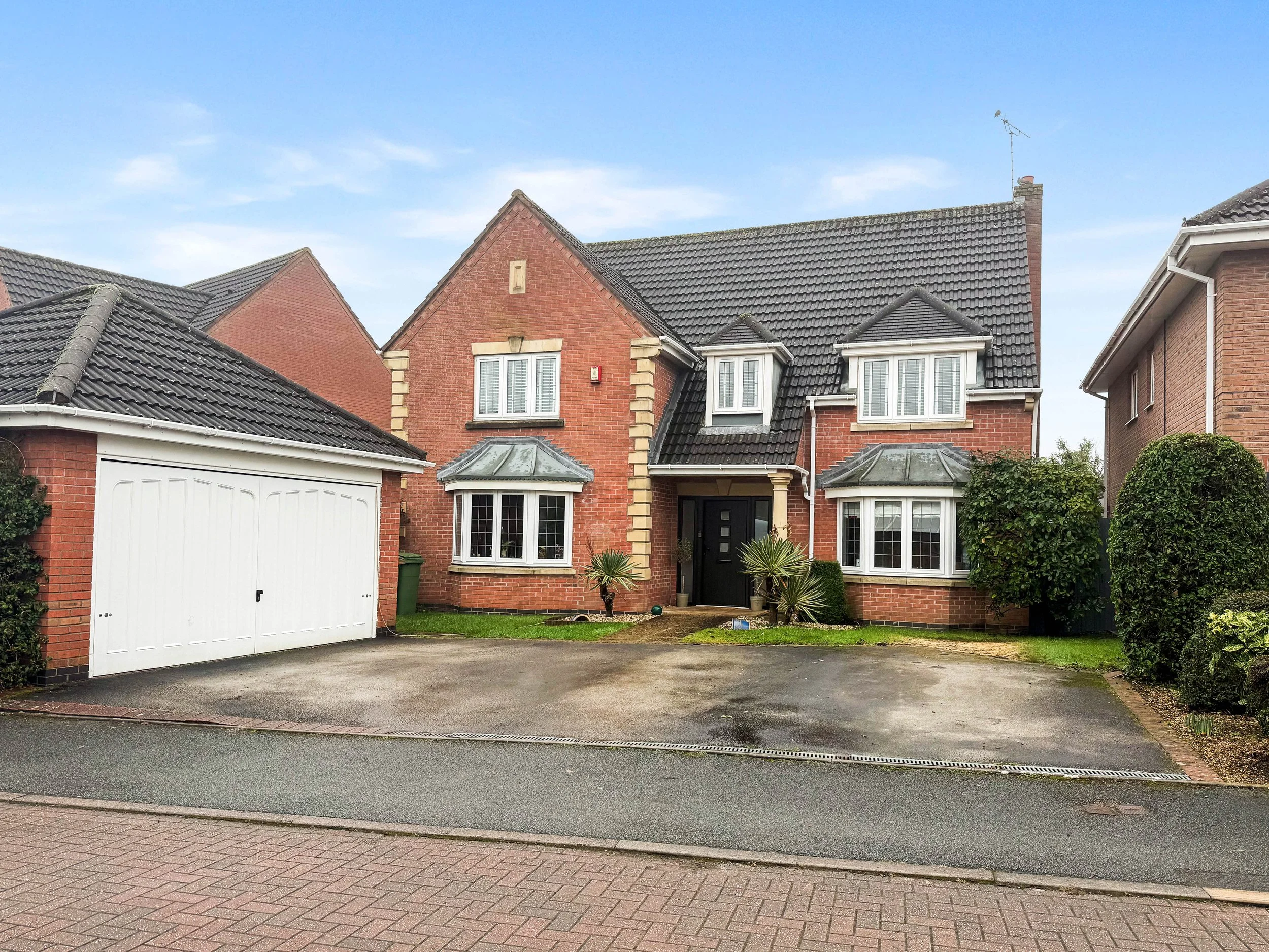 Front exterior of a five bedroom executive detached David Wilson home with double garage and driveway on Coalport Drive, Stone, Staffordshire