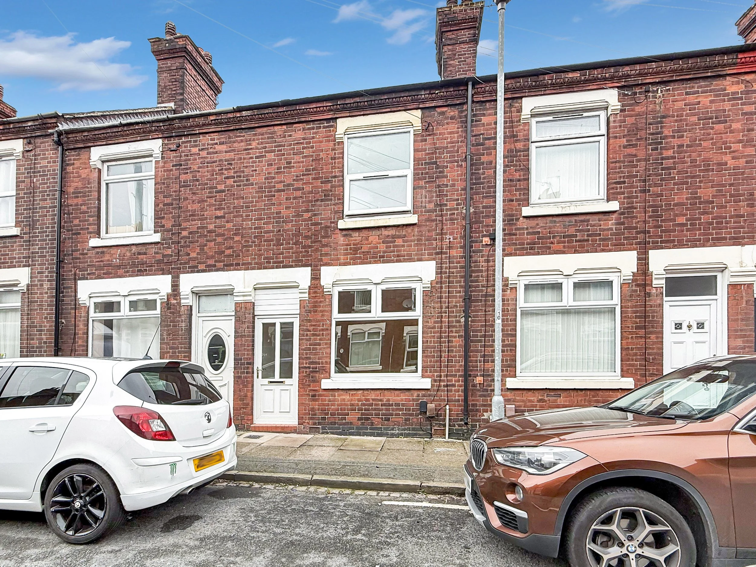 Front view of two bedroom terraced house on Stanier Street, Fenton, Stoke-on-Trent, under a bright blue sky.