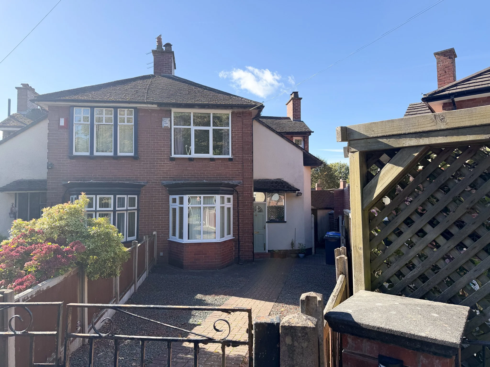 Front exterior of a mature three bedroom brick-built semi-detached house on Lower Crescent, Hartshill, Stoke-on-Trent, featuring bay windows, a driveway, established front garden and pitched tiled roof.