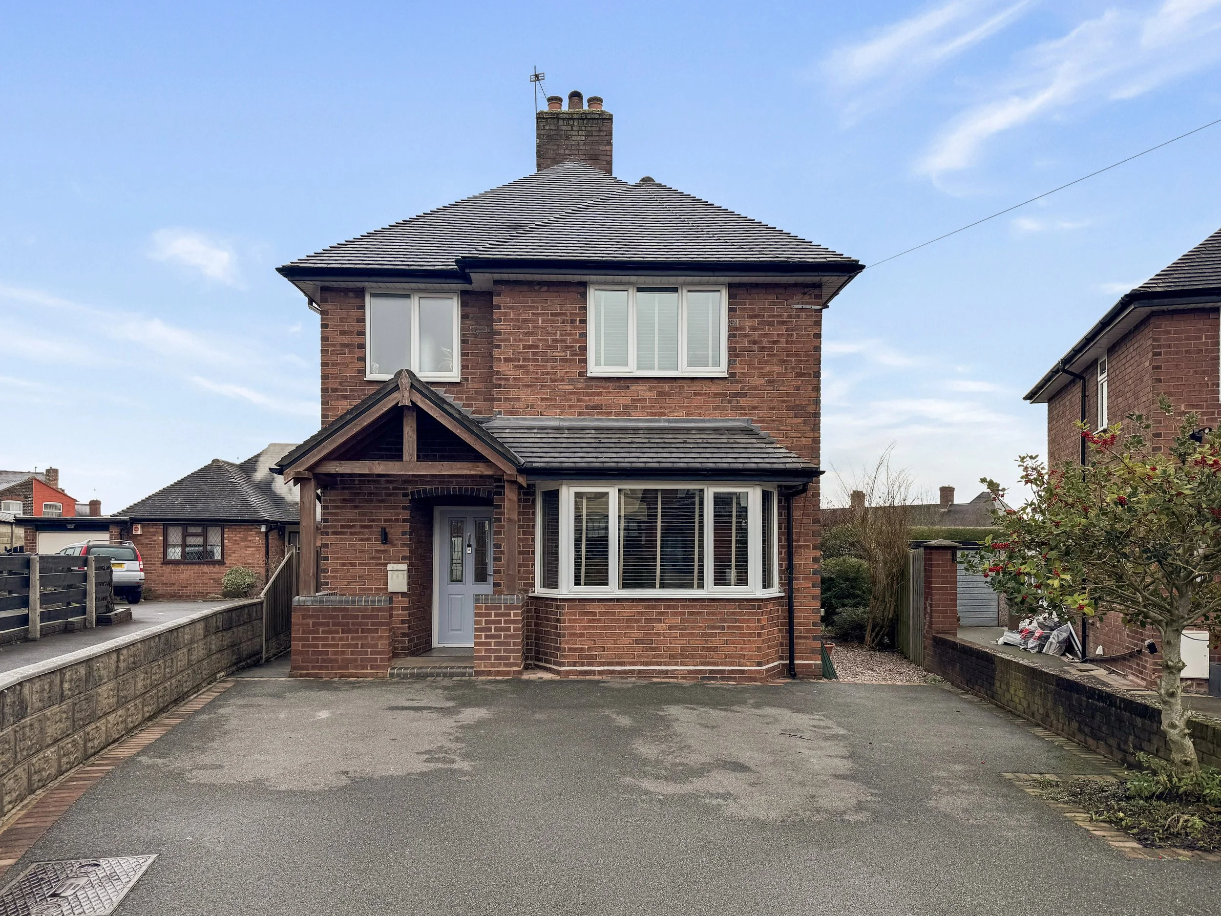 Front elevation of a detached family home on Kingsfield Oval, Basford, Stoke-on-Trent ST4, featuring a large driveway, bay window and brick-built exterior.