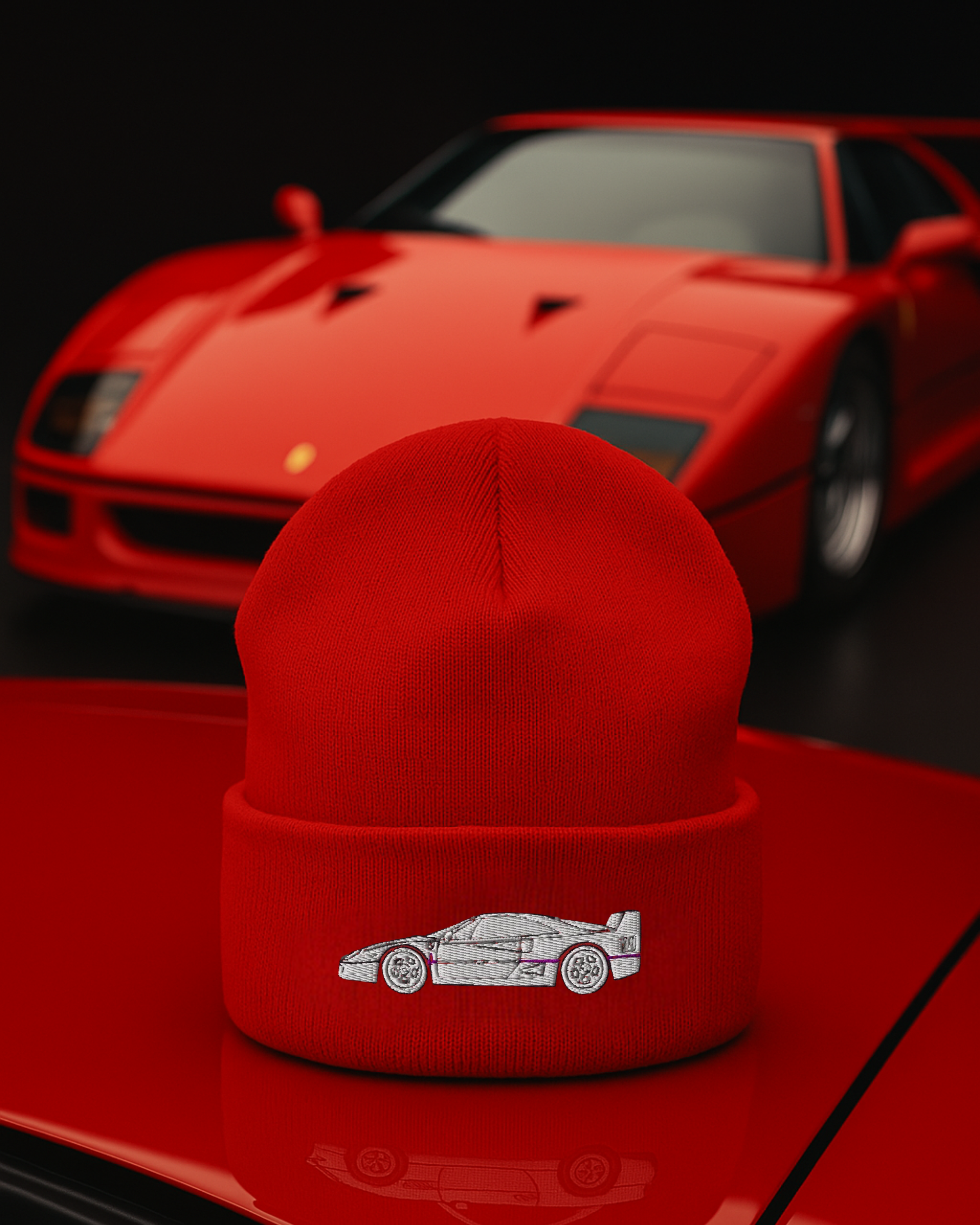 Red knit hat with car embroidery in front of a matching red sports car.