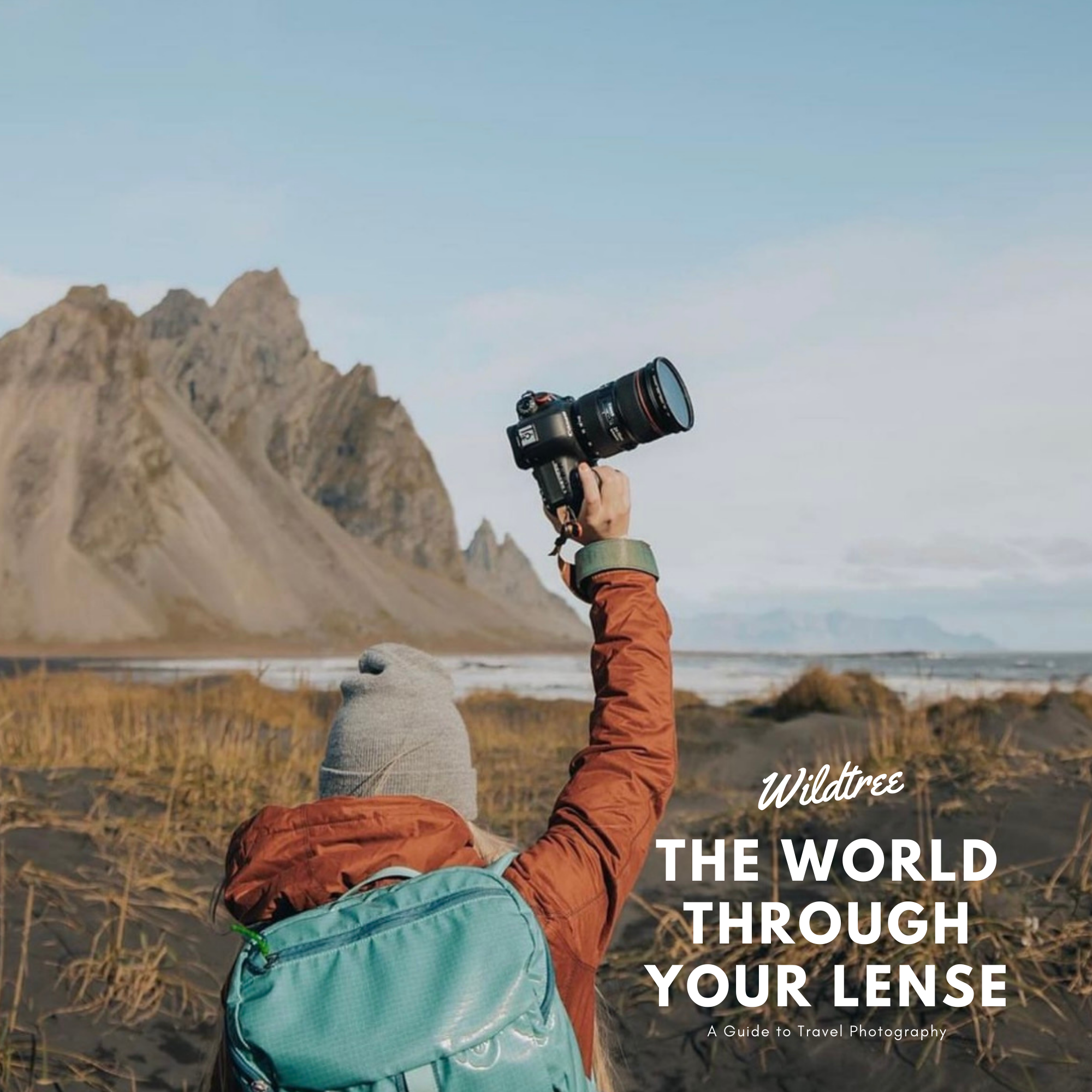 Woman holding up a camera outside with the text "Wildtree: A Guide to Travel Photography"