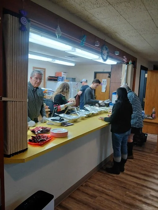 Multiple people lined up to receive food from volunteers