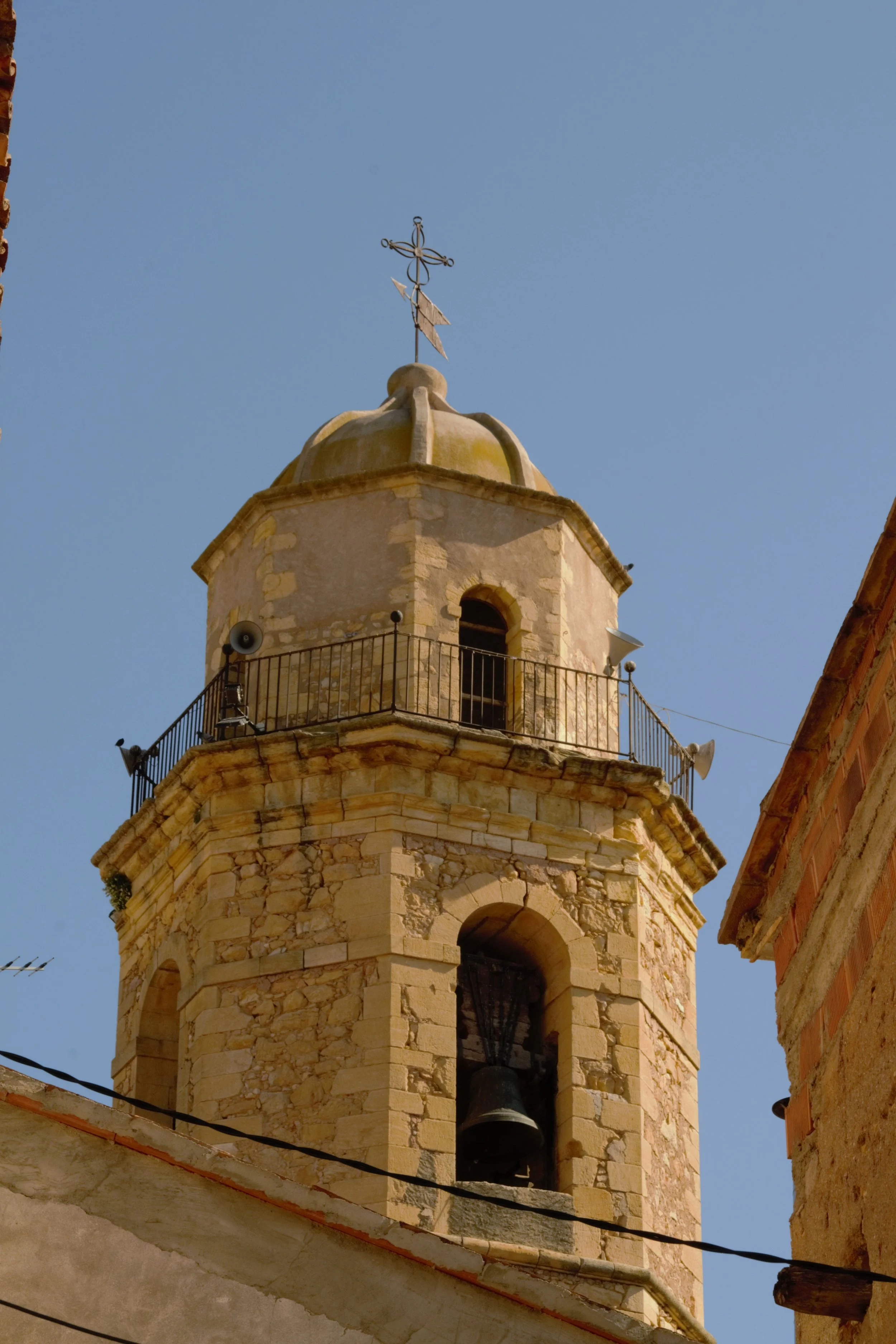 Primer pla del campanar de Sant Miquel d’Os de Balaguer amb la campana i la cúpula.