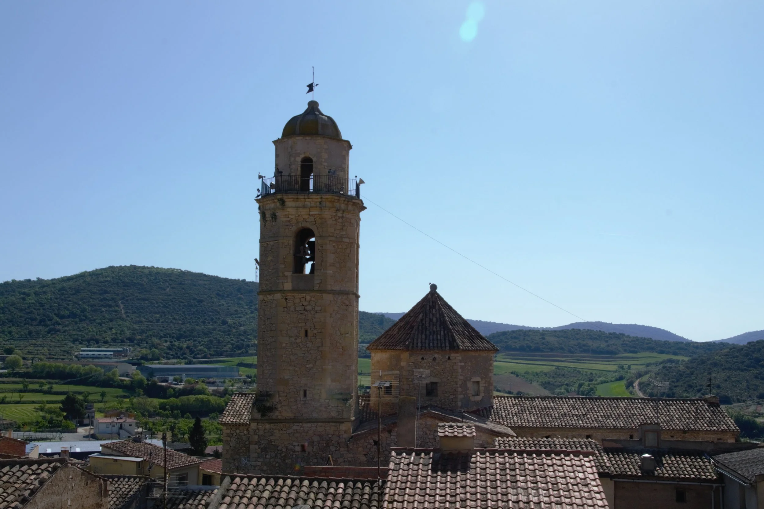 Campanar de Sant Miquel d’Os de Balaguer amb el paisatge de la Noguera al fons.