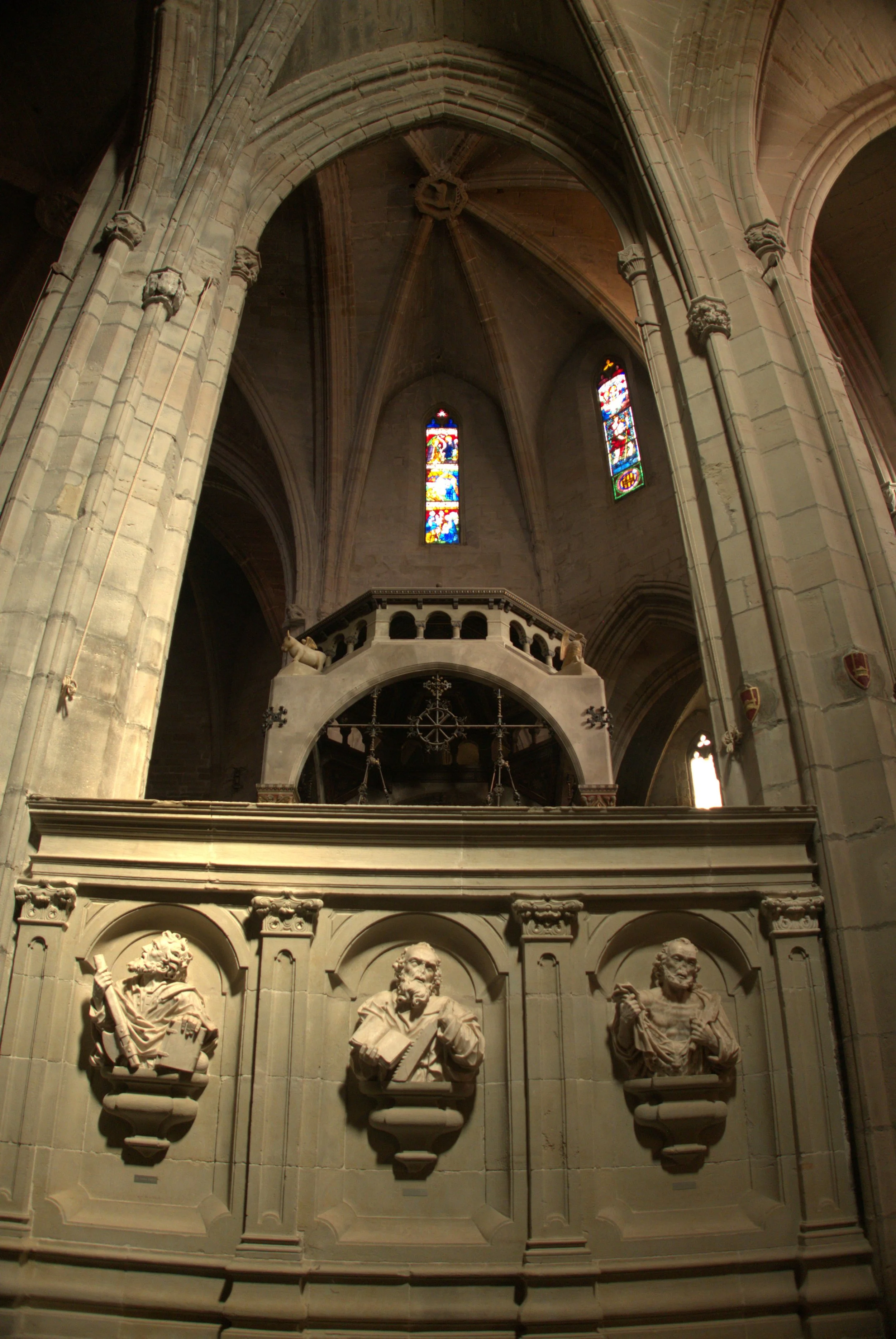 Detall interior de Santa Maria de Cervera amb arcs gòtics, vitralls i elements escultòrics.