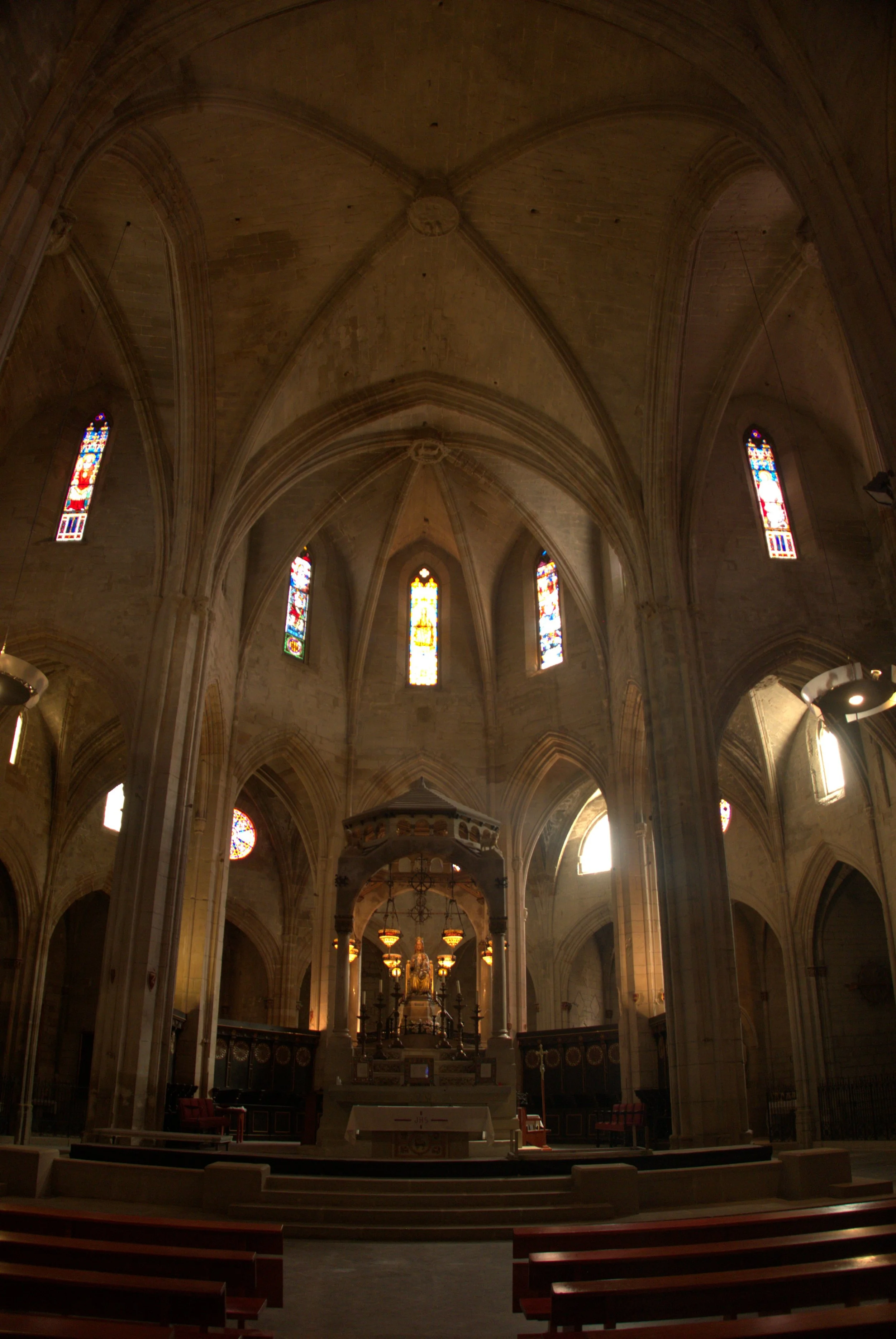 Interior de Santa Maria de Cervera amb l’altar major, vitralls i voltes gòtiques.