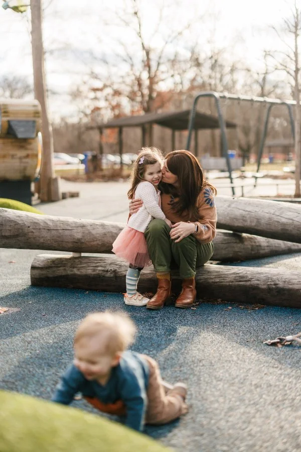 A mom and her two kids playing at the playground in Sharon woods for family photos in cincinnati ohio.