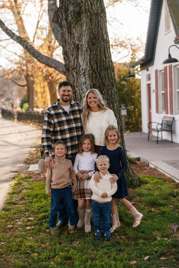 A family of six smiling and laughing during fall family photos in Loveland Ohio near the bike trail.