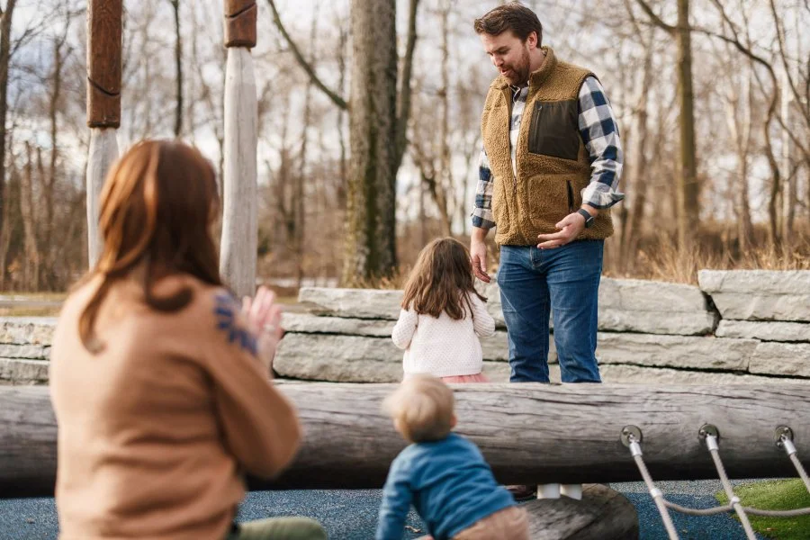 Affordable family photographer in Cincinnati, Ohio capturing a family of four playing on a playground.