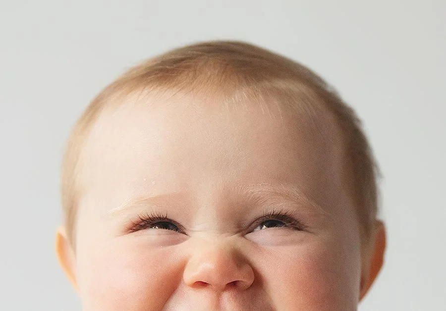 milestone baby photo session with baby smiling and close in face crop