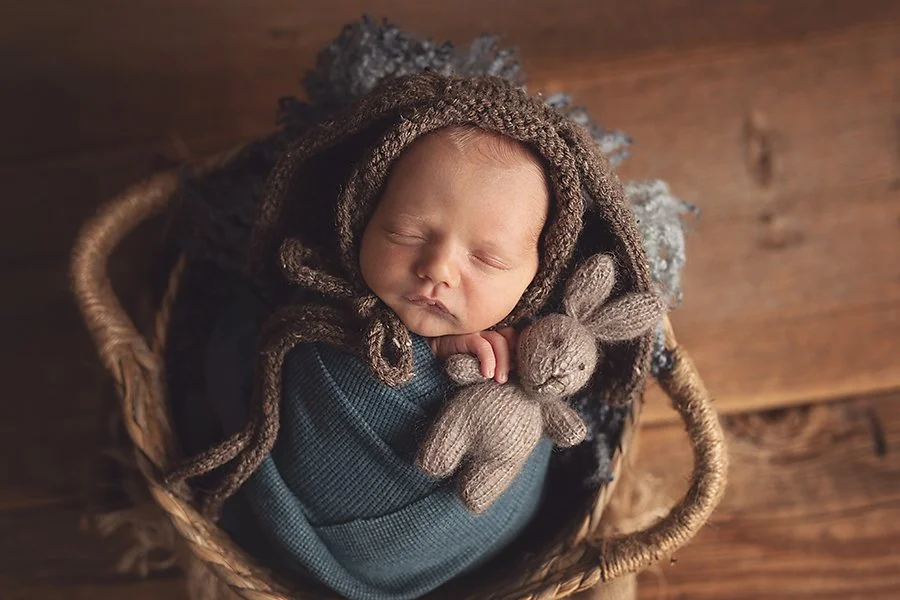 newborn baby in bunny hat snuggling knit bunny toy in a newborn family photography studio in greencastle pa.