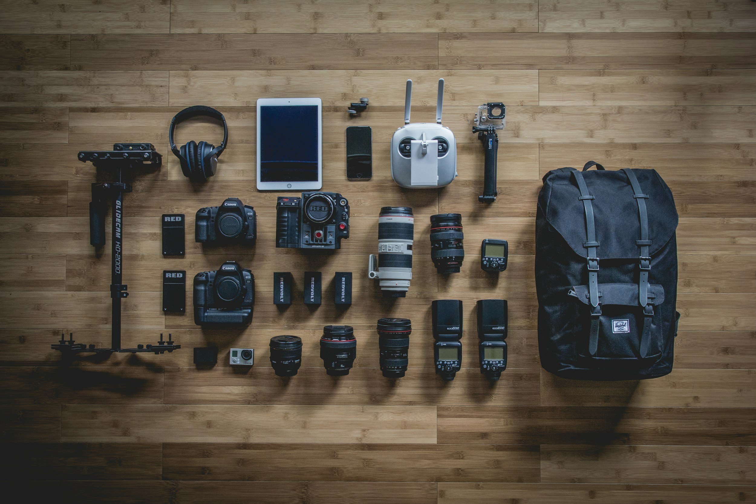 Camera bag gear spread on a wooden table.