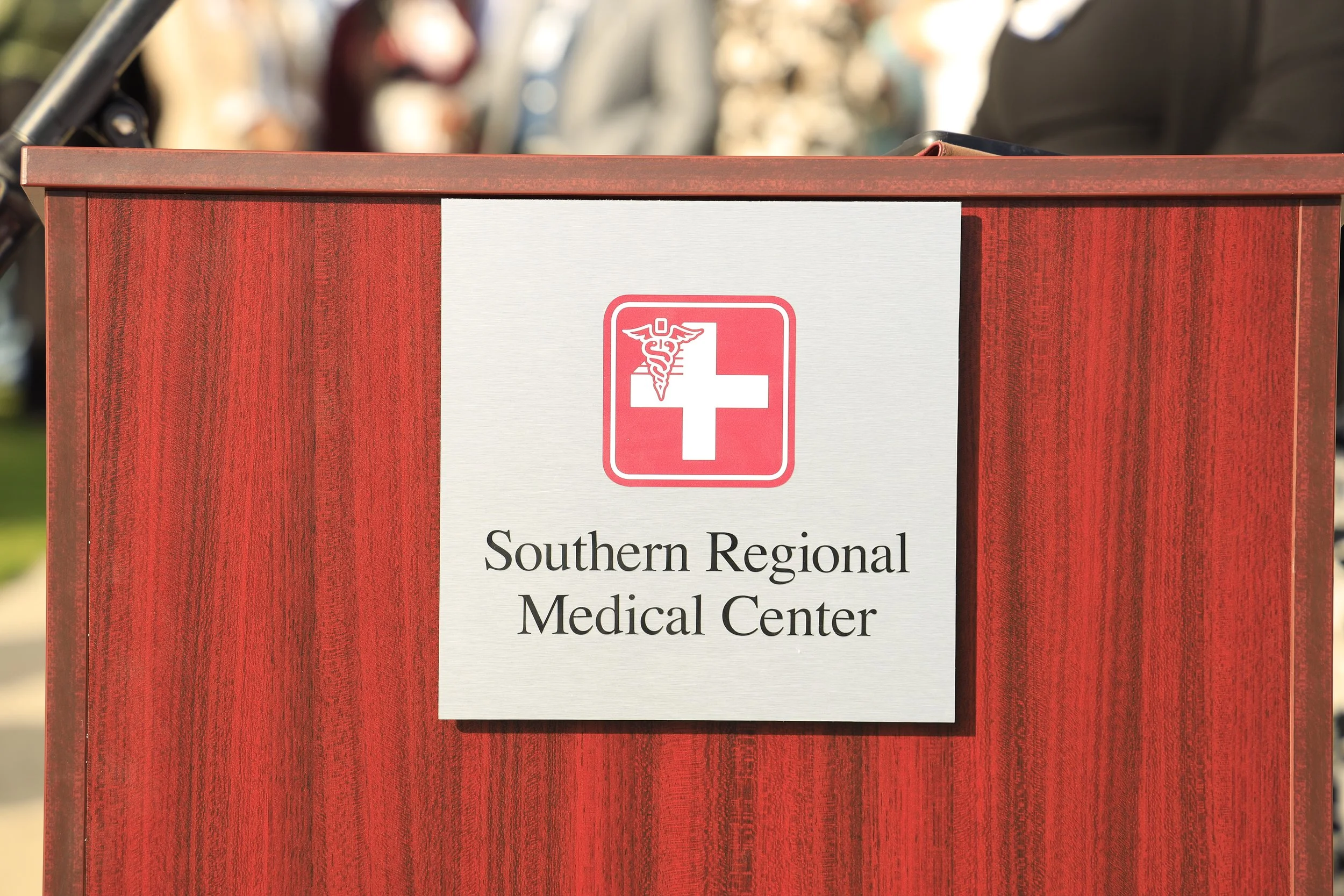 Red wooden medical donation or disposal box with a white sign reading "Southern Regional Medical Center" and a medical emblem, featuring a red cross and caduceus symbol.