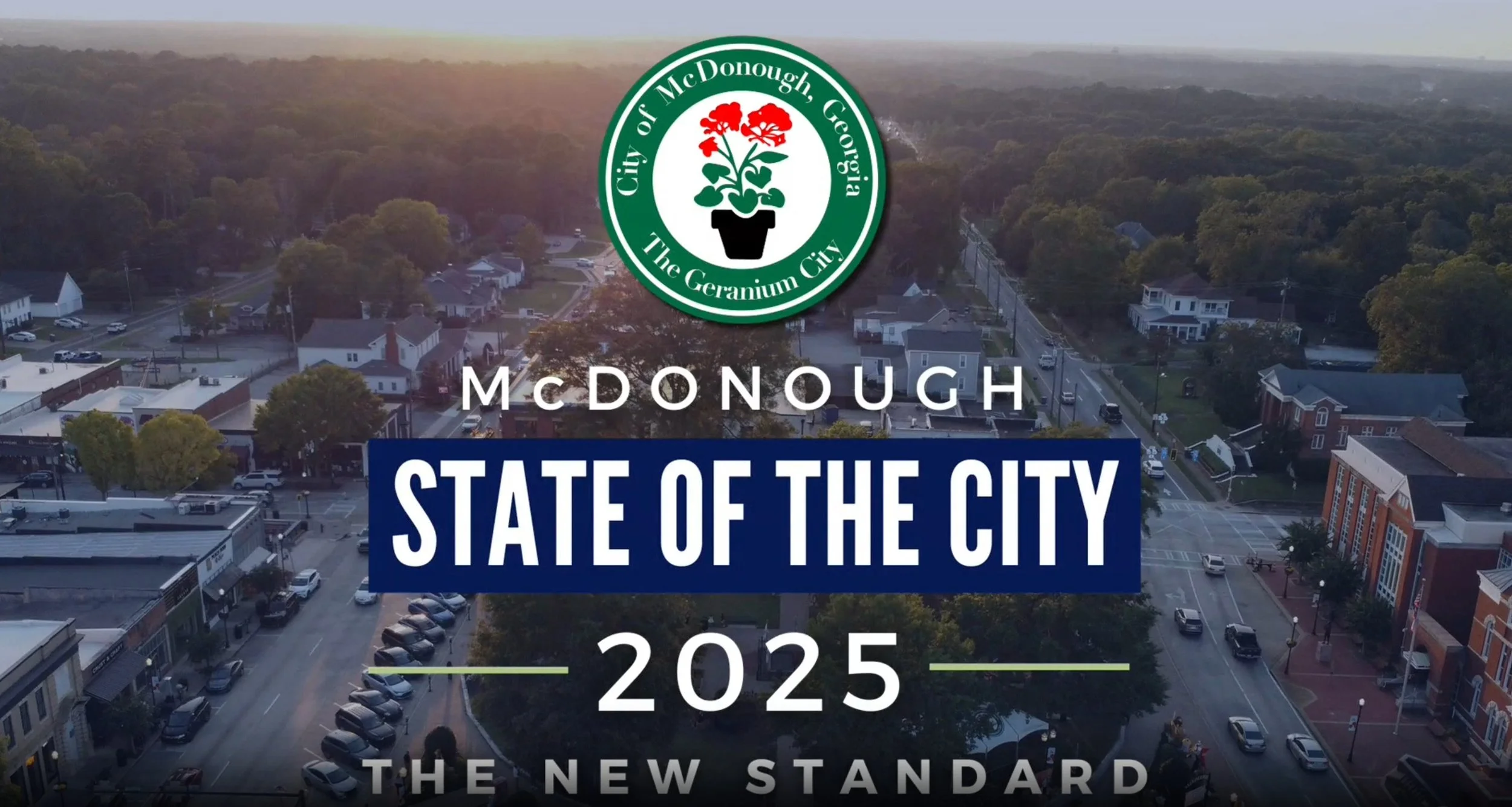 Computer monitor displaying video editing software with a landscape image, timeline, and editing tools, in a dark room with a colorful illuminated keyboard and mouse.