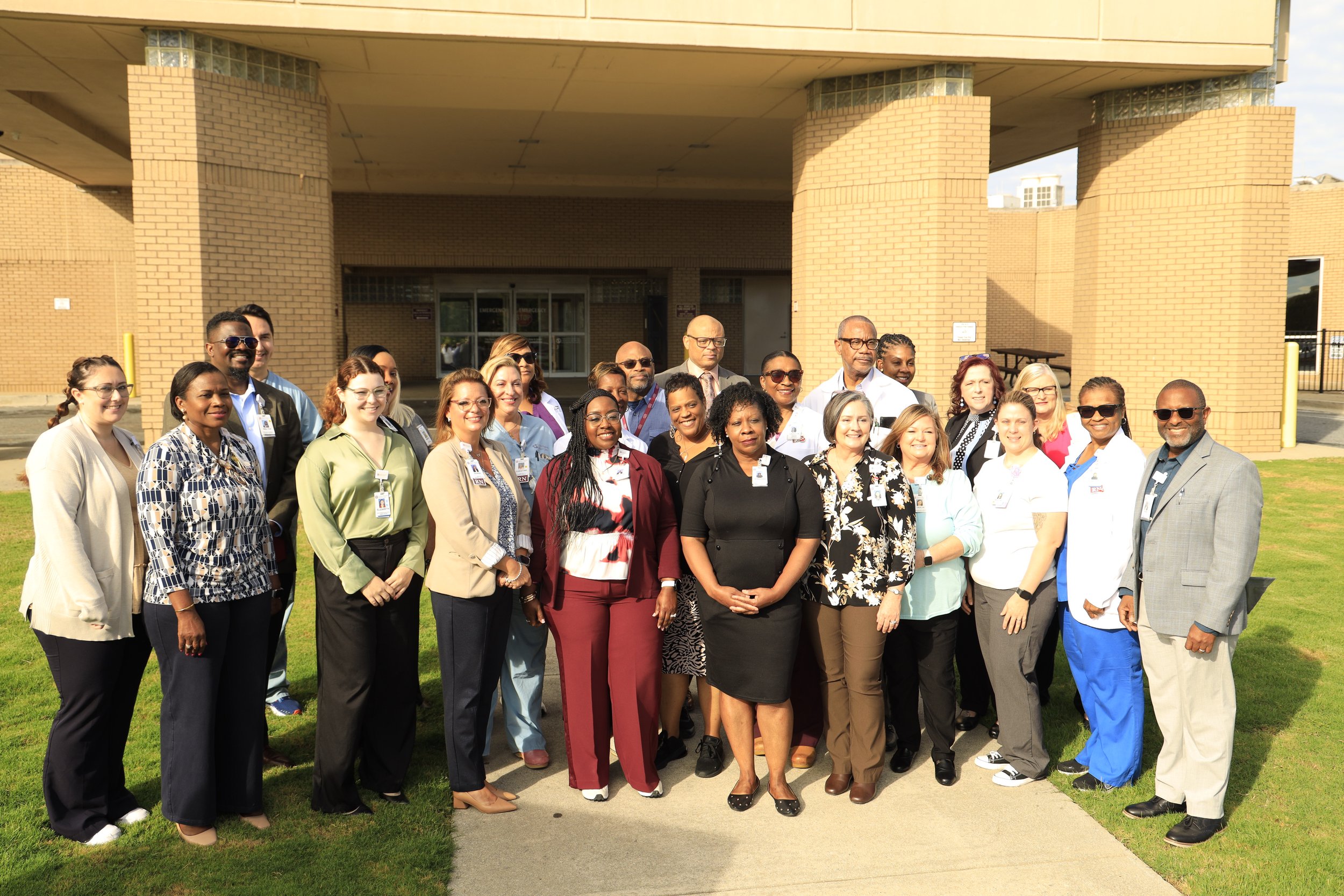 Group of healthcare professionals standing outside a hospital building.