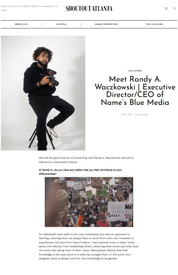 A group of diverse people standing in a line with their hands raised and clasped together, smiling and celebrating on a dark stage.