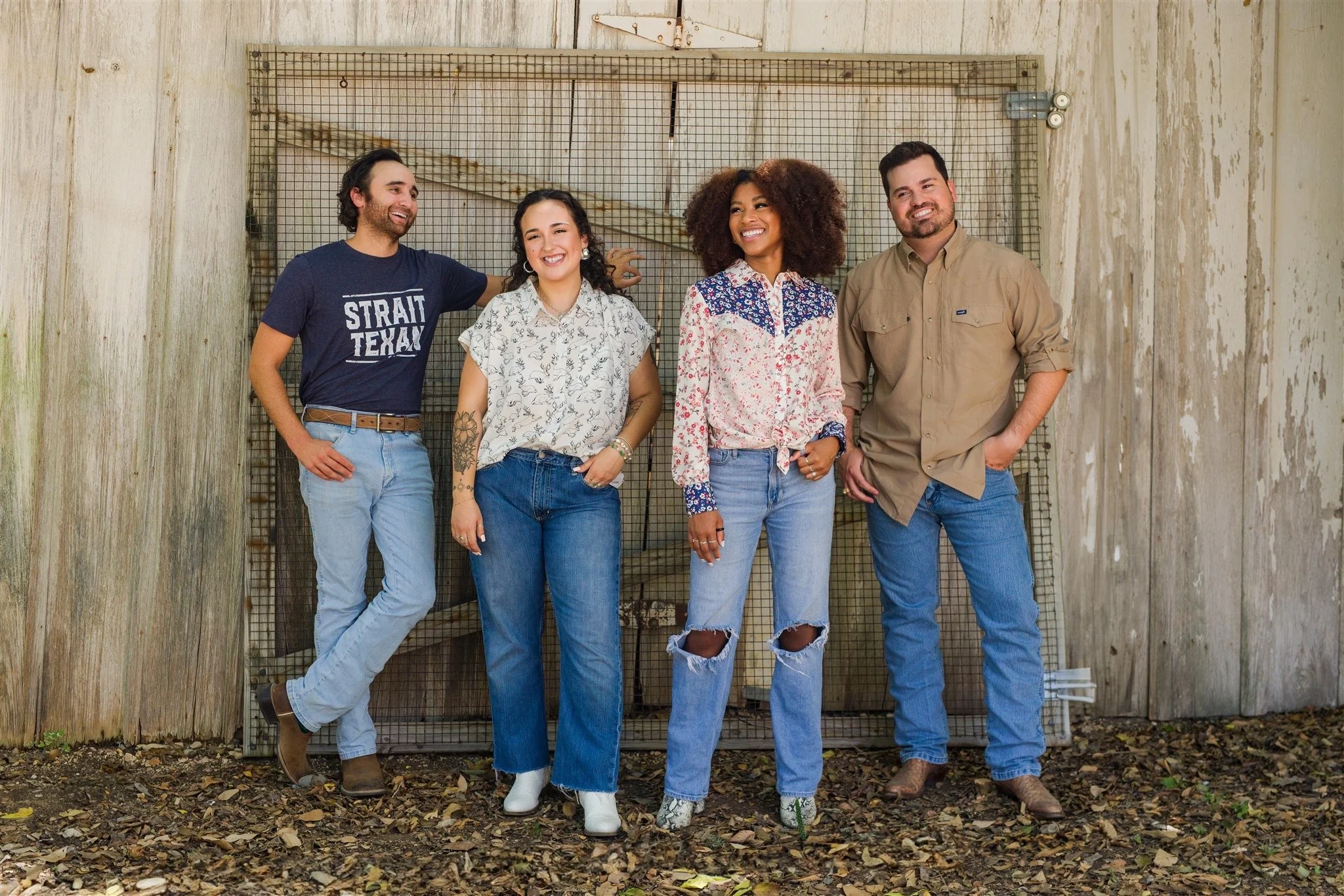 Casual lifestyle branding portrait of four professionals standing together in front of a rustic wood wall in San Antonio.
