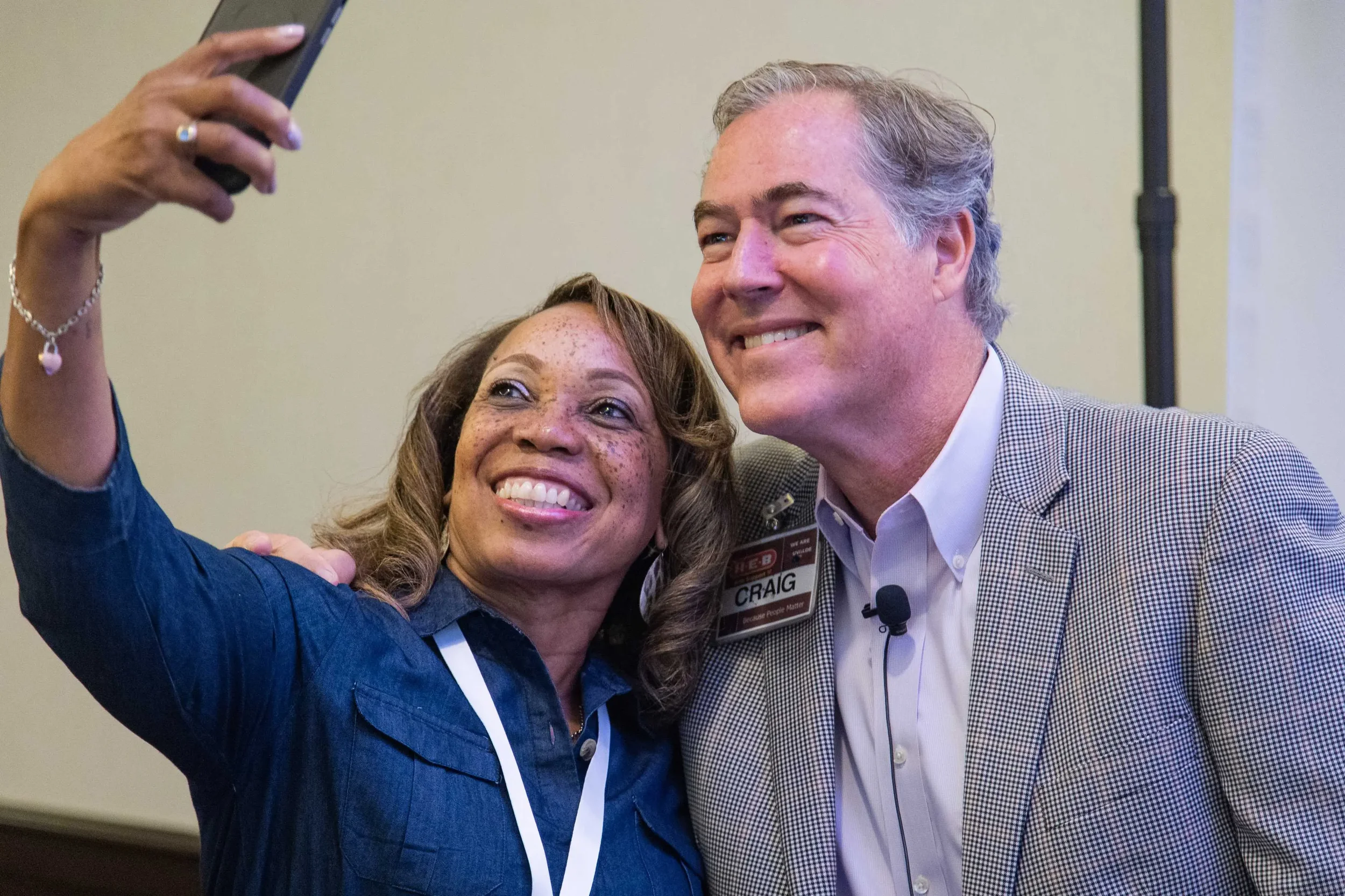 Conference attendee taking a selfie with a keynote speaker during a professional networking event.
