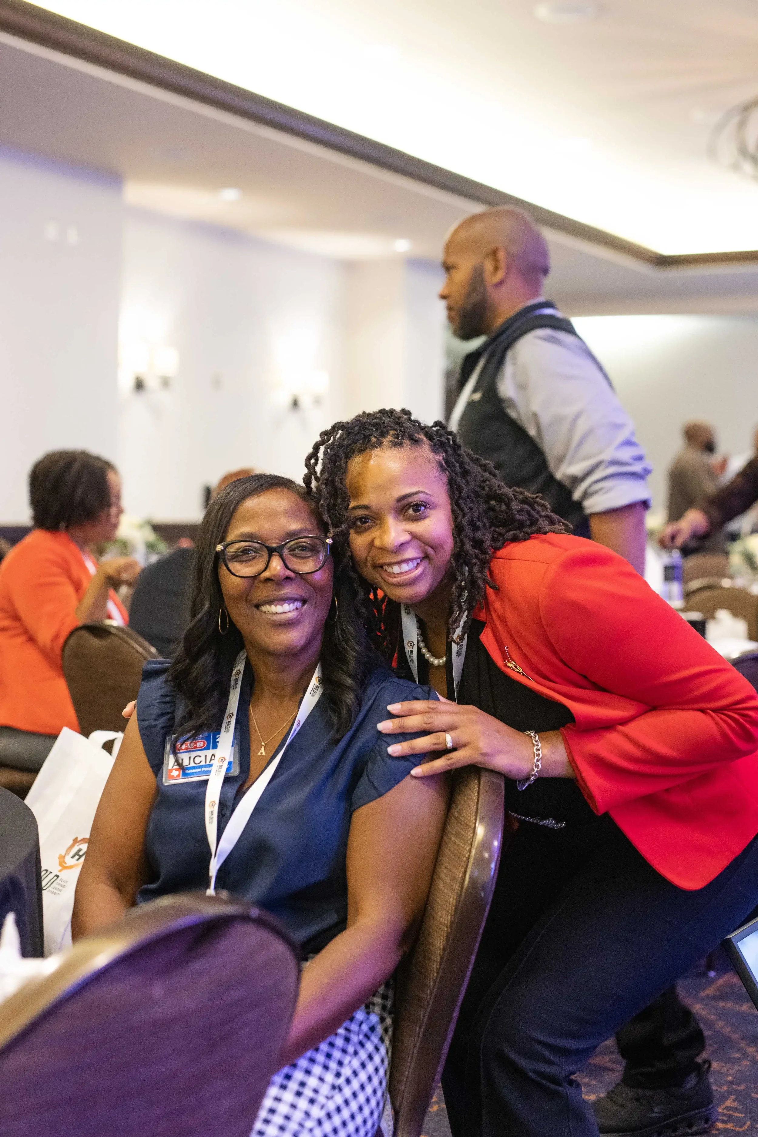 Two conference attendees smiling together during a HEB leadership event in a banquet setting.