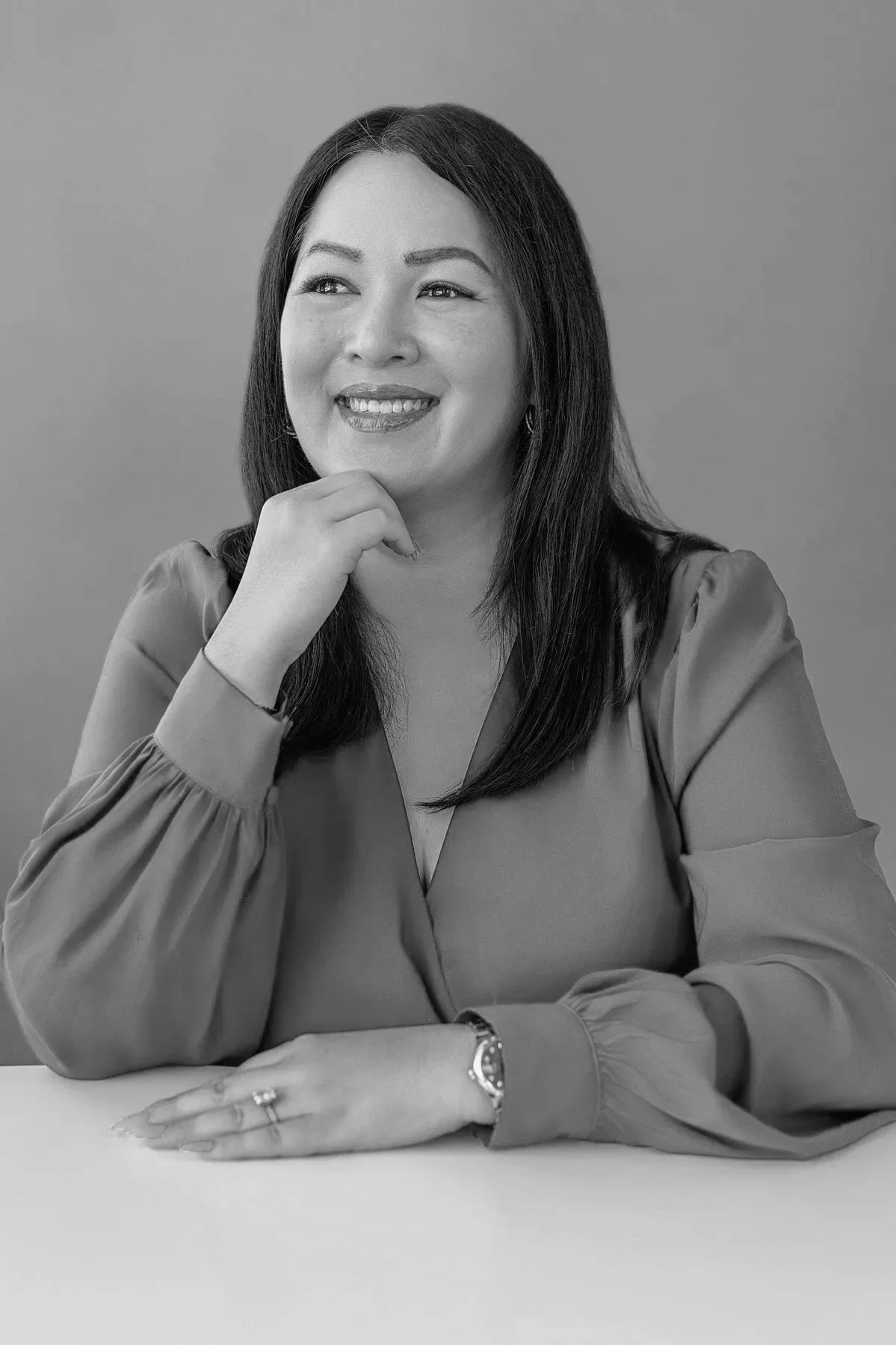 Branding portrait of a woman sitting on a sofa holding a tablet next to a color analysis chart on an easel, captured in San Antonio.